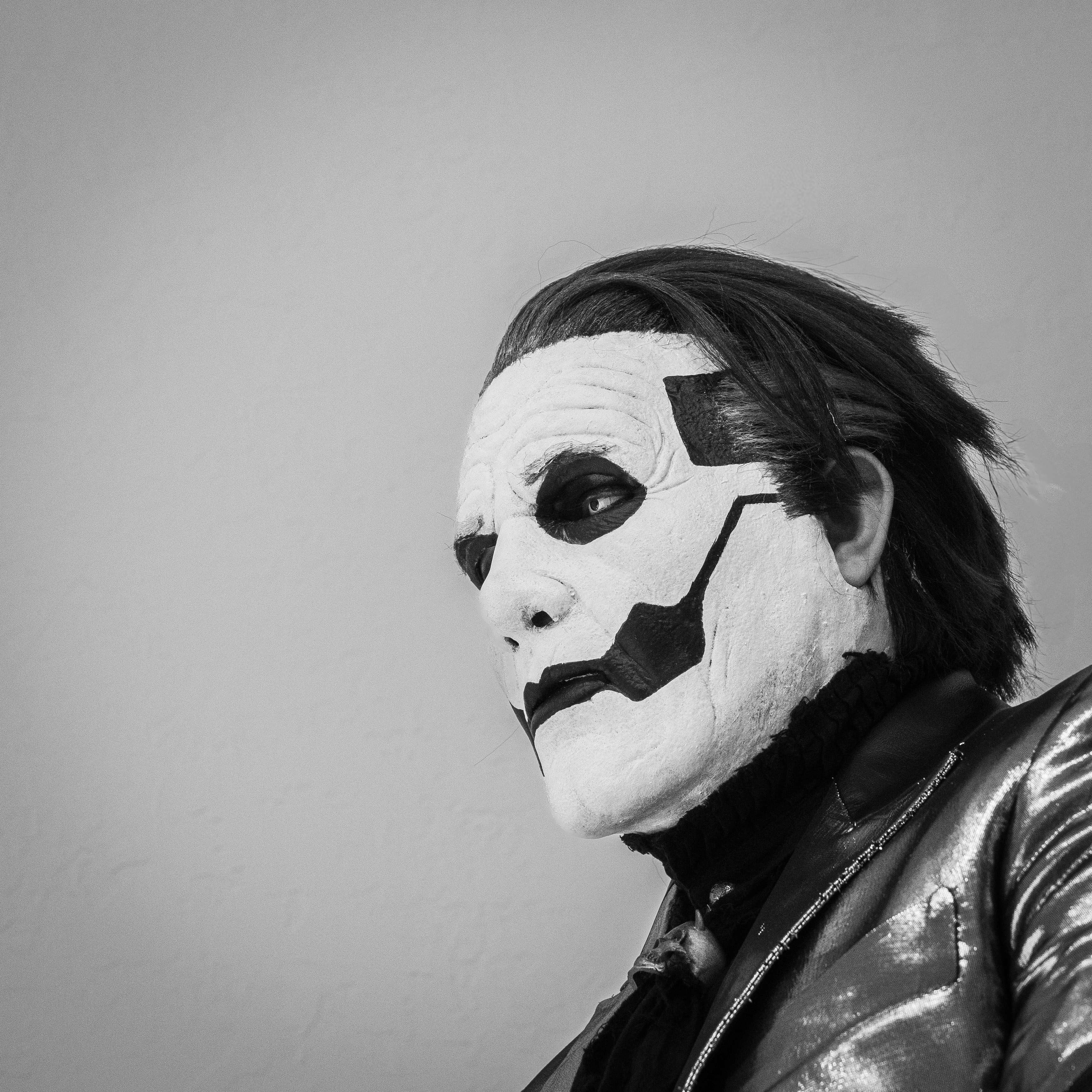 a black and white photo of a man dressed as a clown