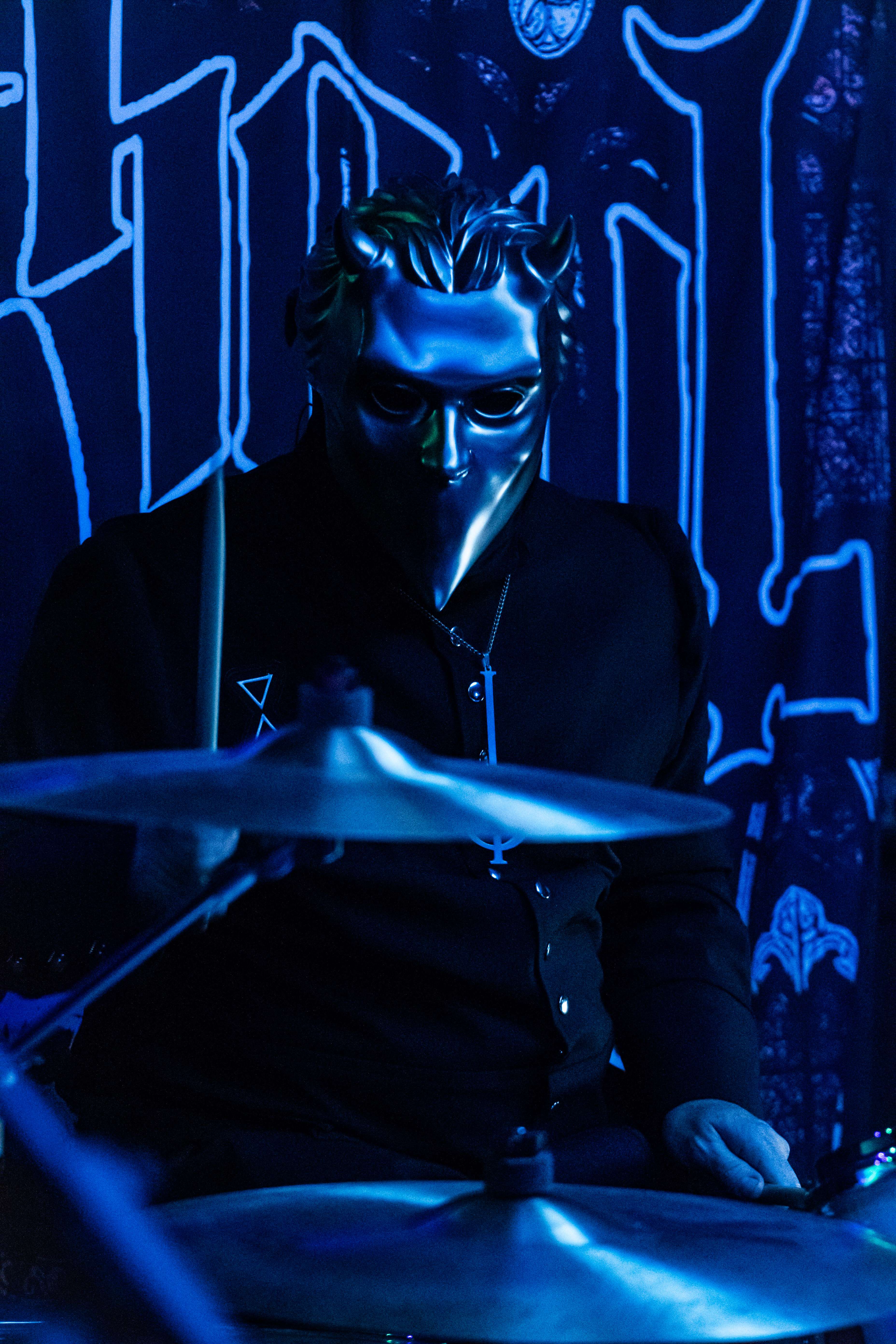 a man in a mask playing drums