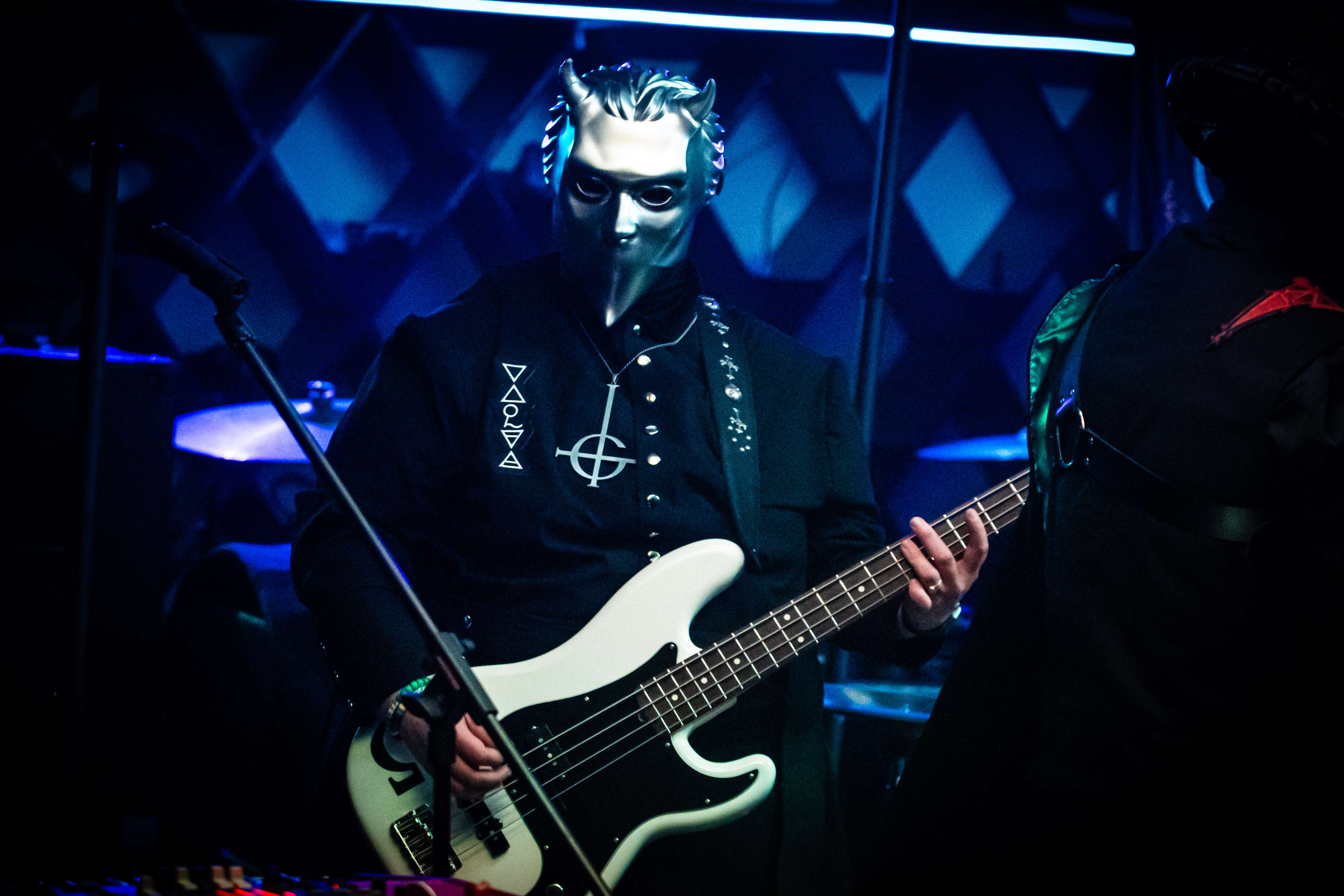 a man in a mask playing a bass
