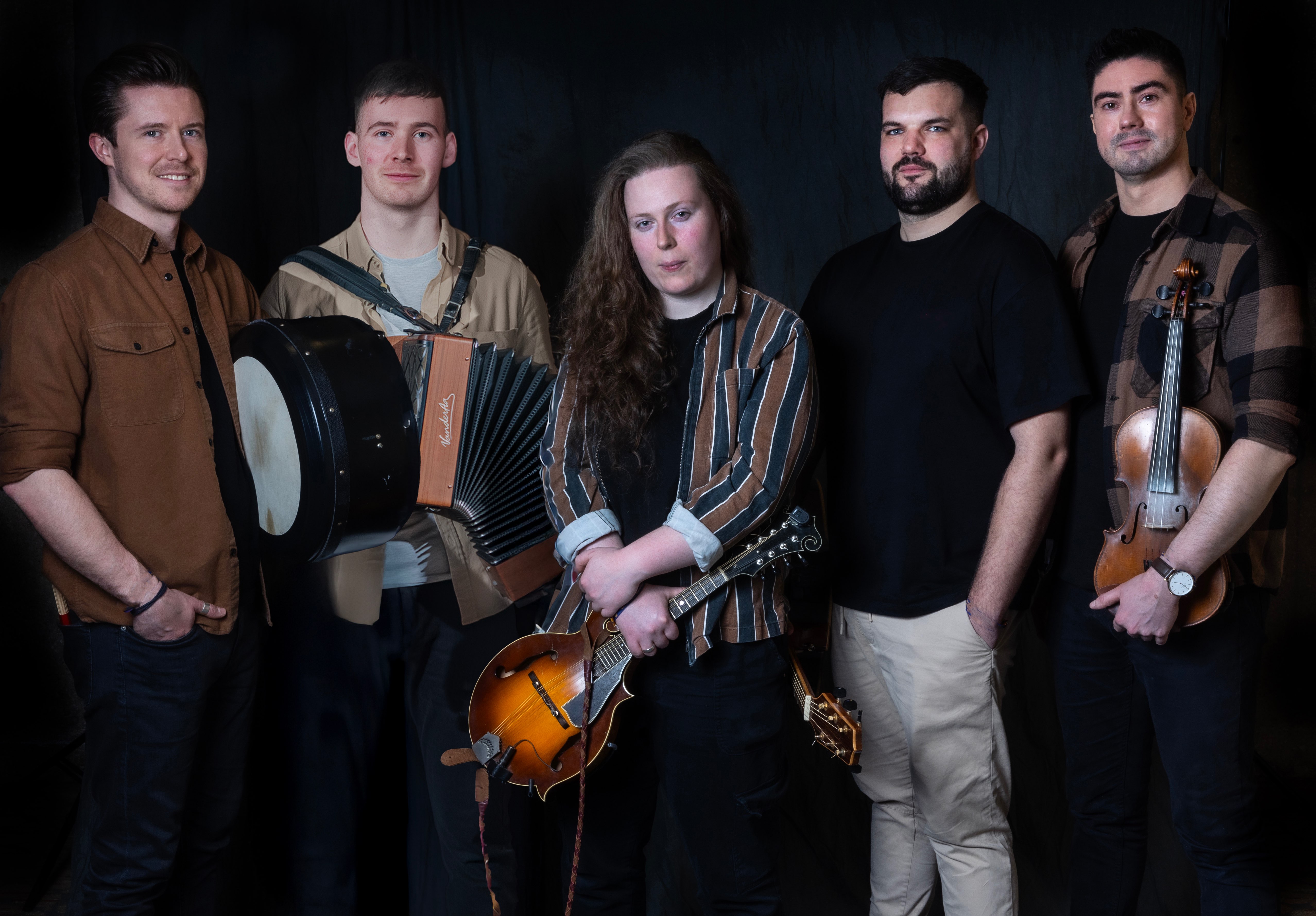 a group of people posing in front of a black background