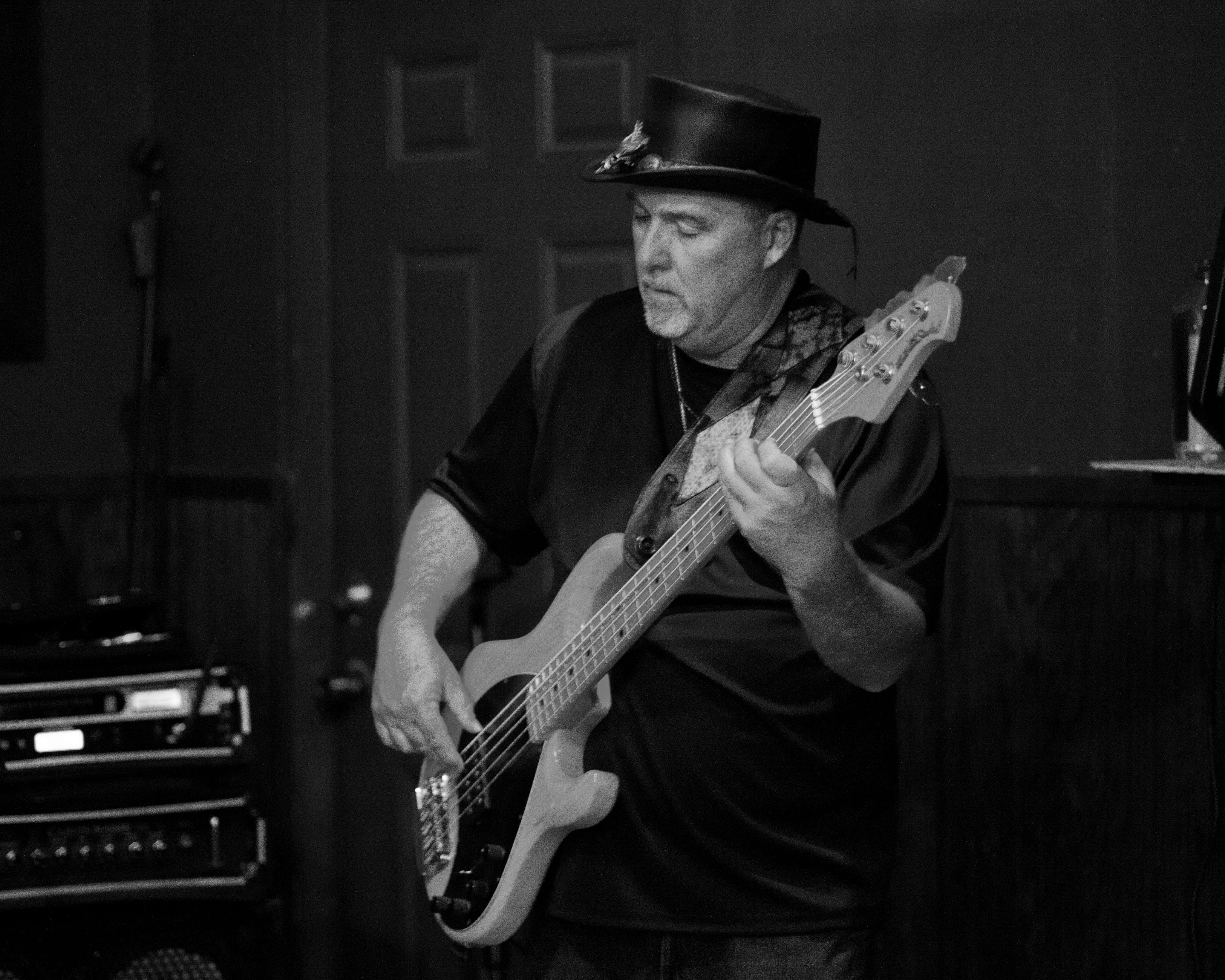 a man playing a bass in a black and white photo