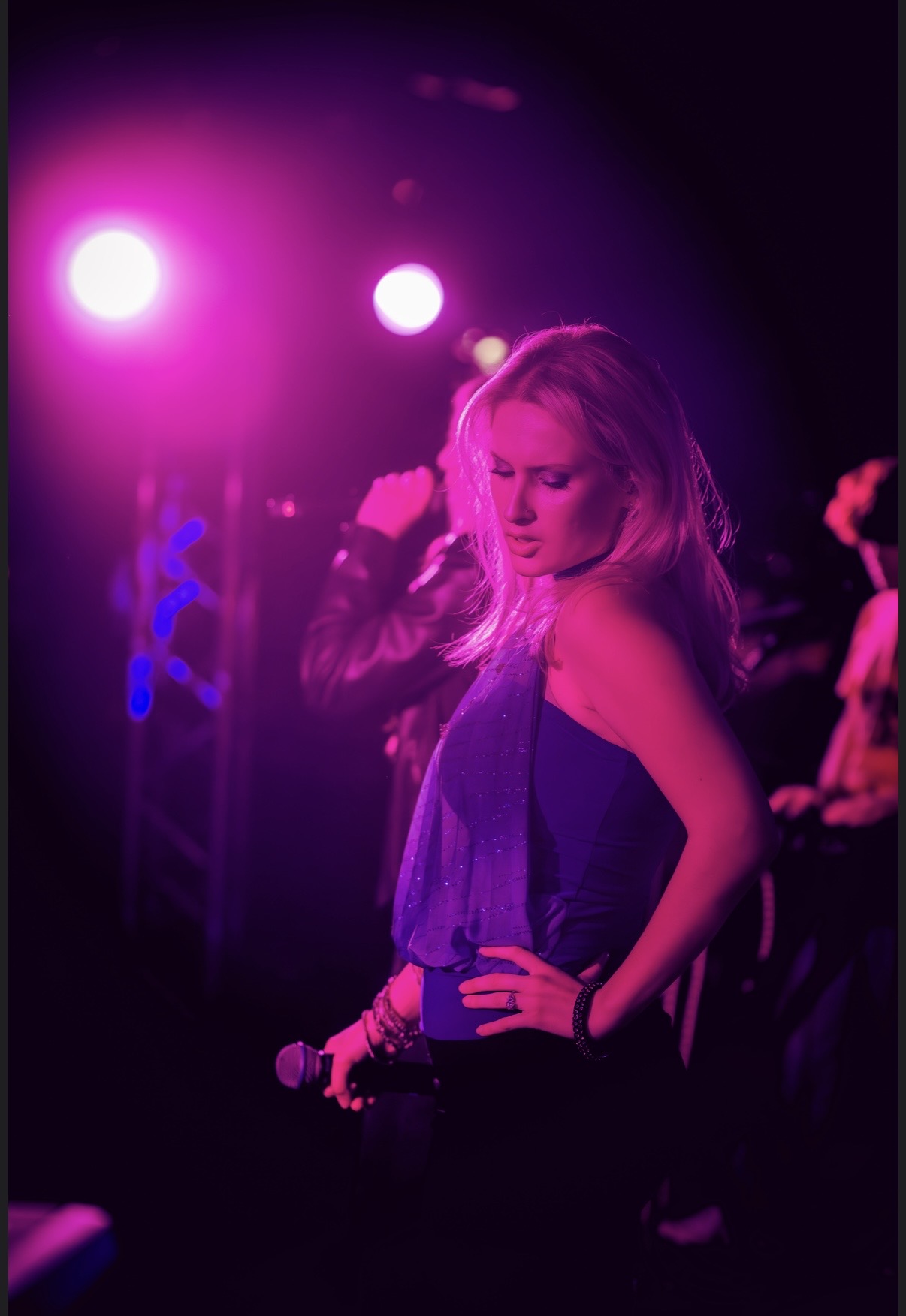 a woman standing on stage with a microphone