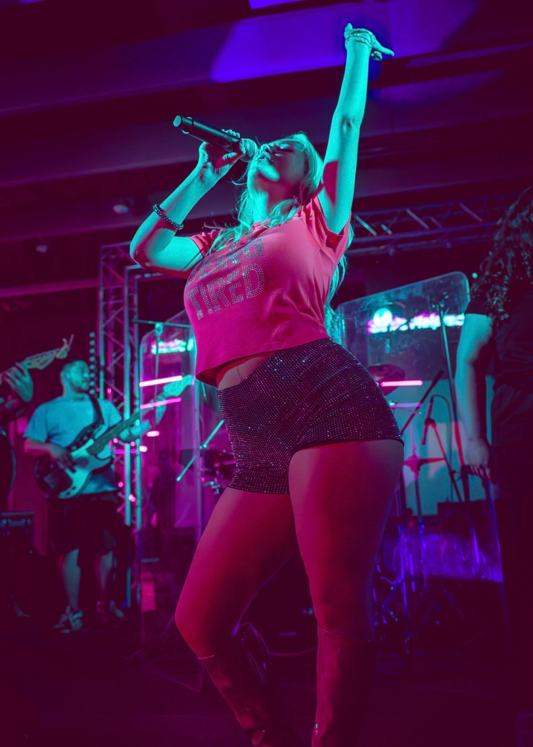 a woman is performing on stage with a microphone
