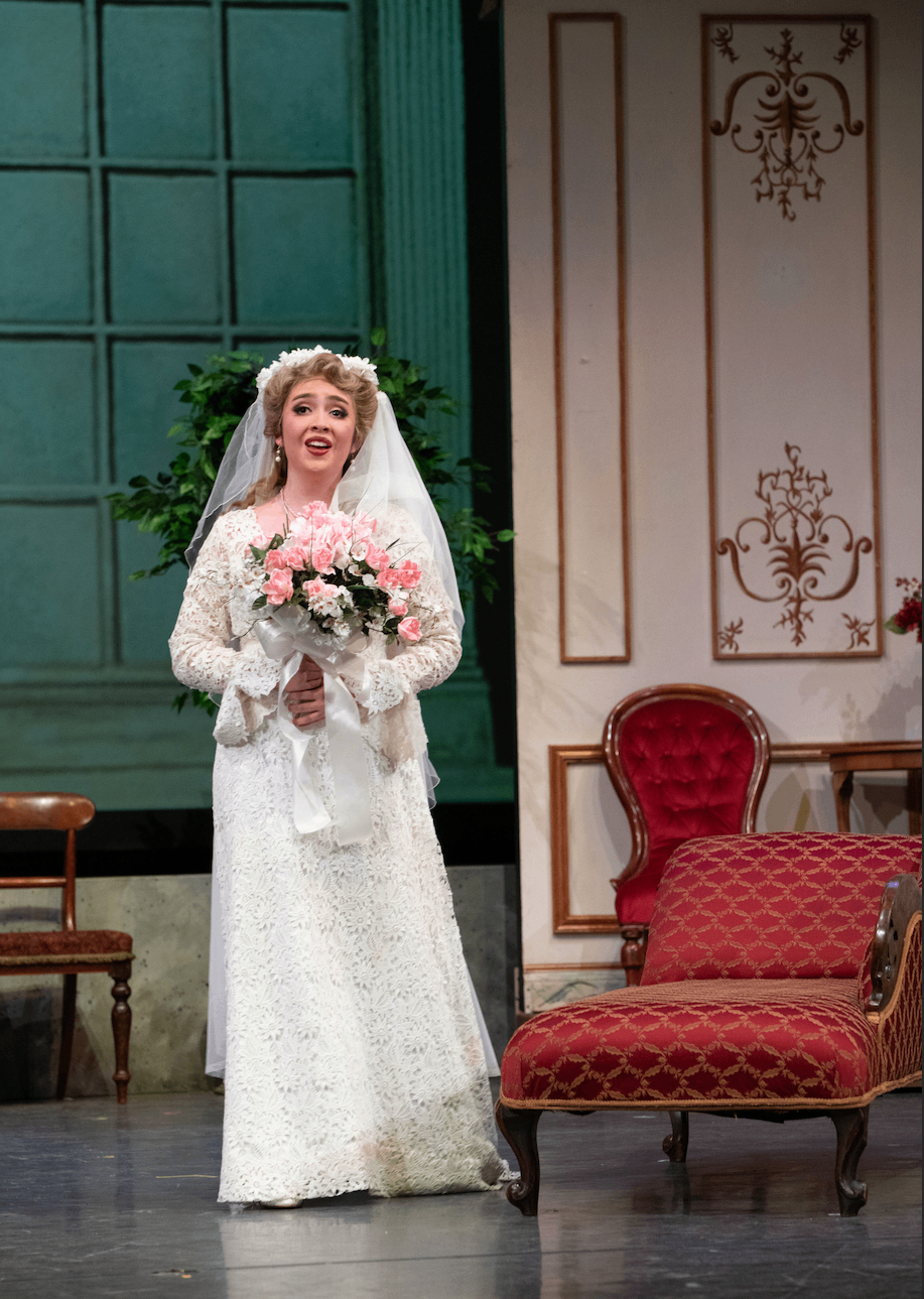 a woman in a wedding dress standing on a stage