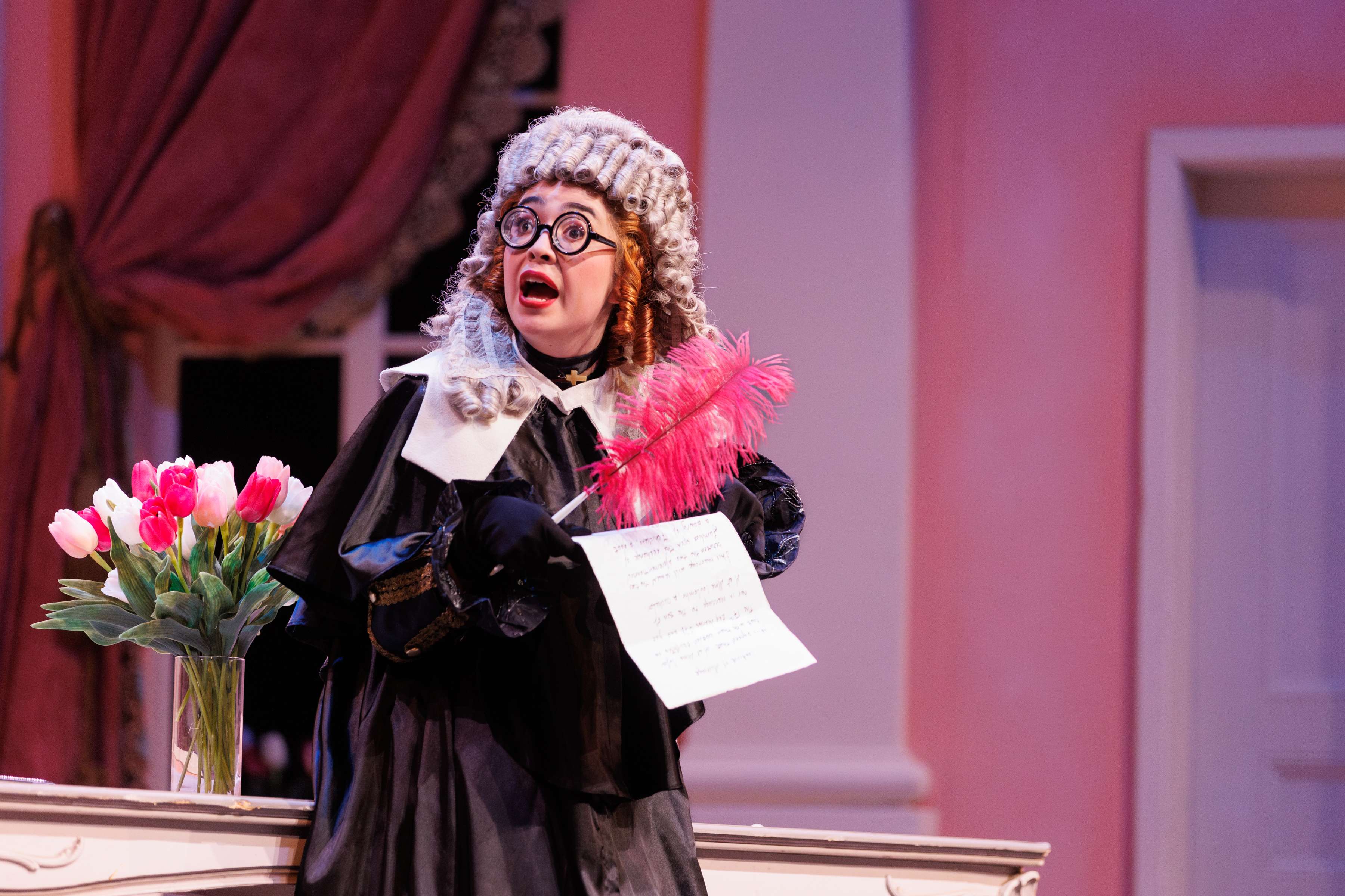 a woman dressed as a judge is holding a bouquet of flowers