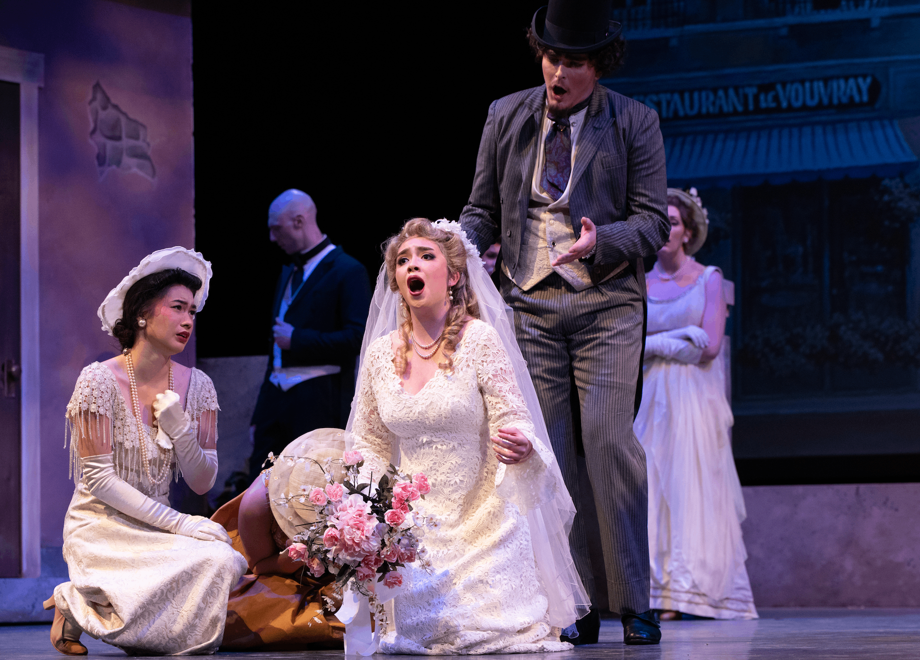 a group of people on stage with a bride and groom