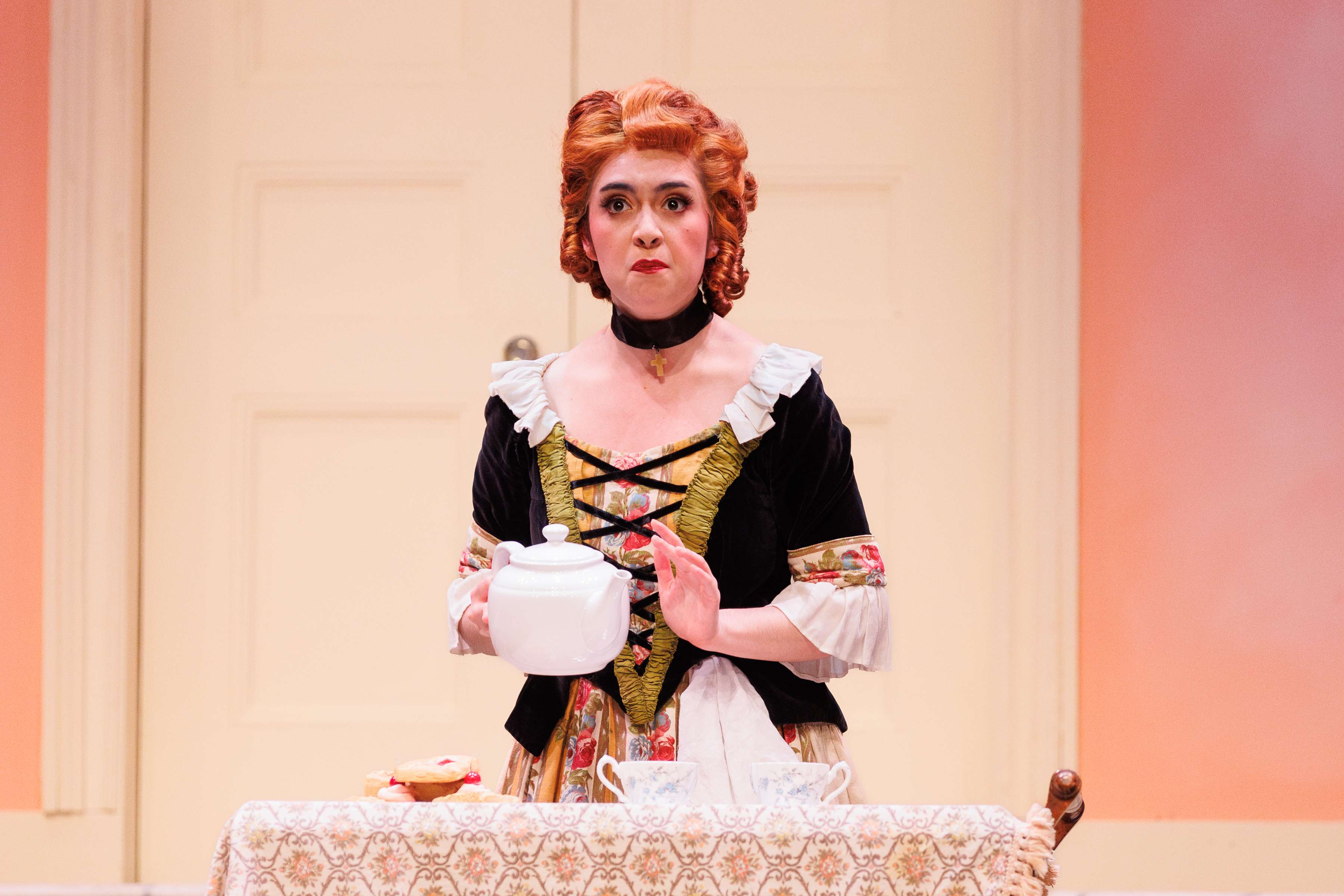 a woman in a costume is holding a teapot