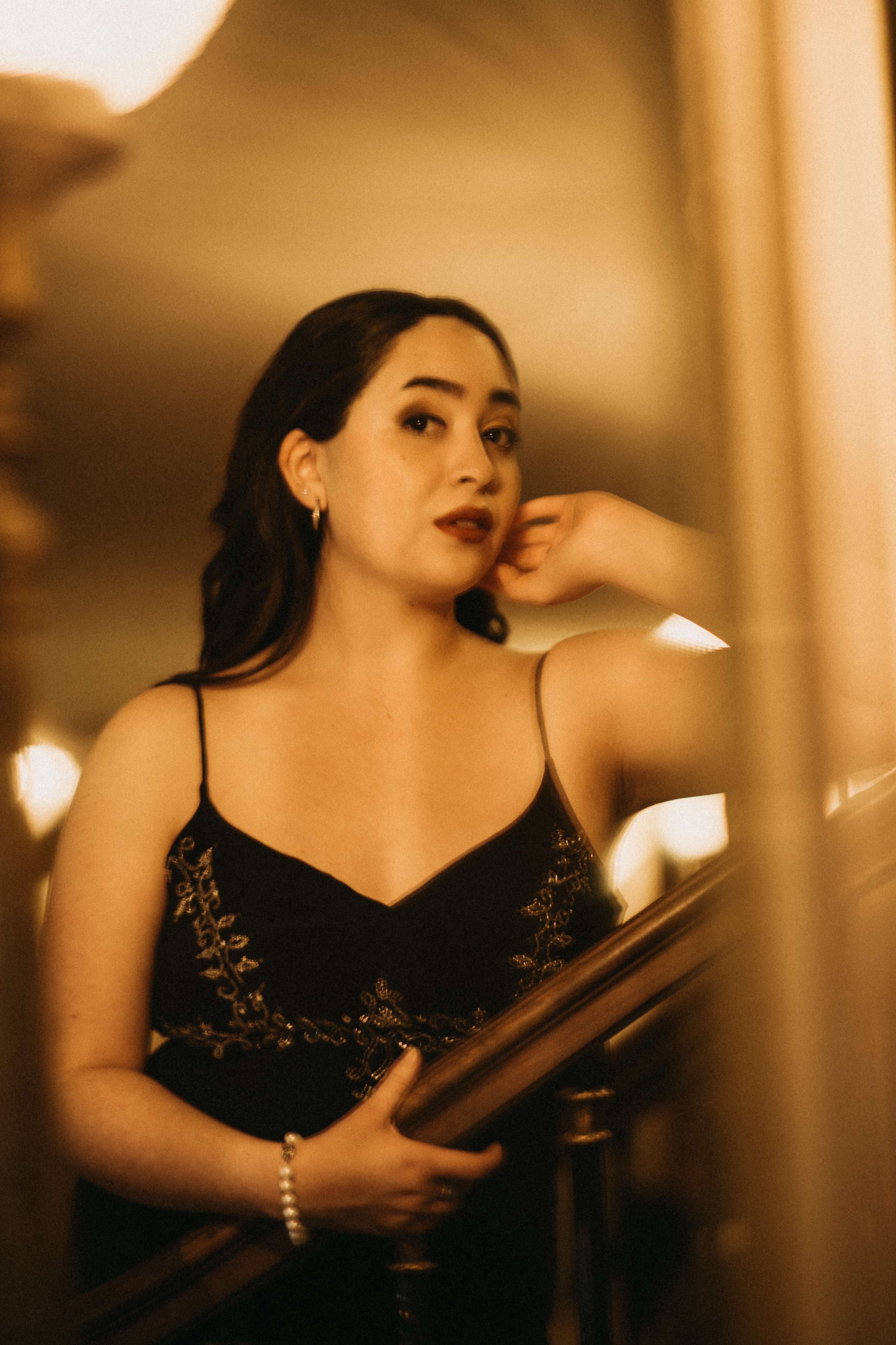 a woman in a black dress posing in front of a mirror