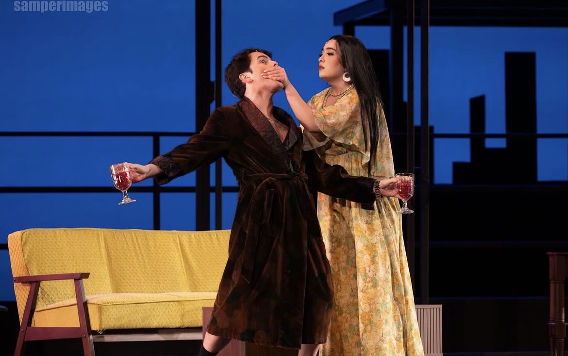 a woman in a dress is holding a glass of wine