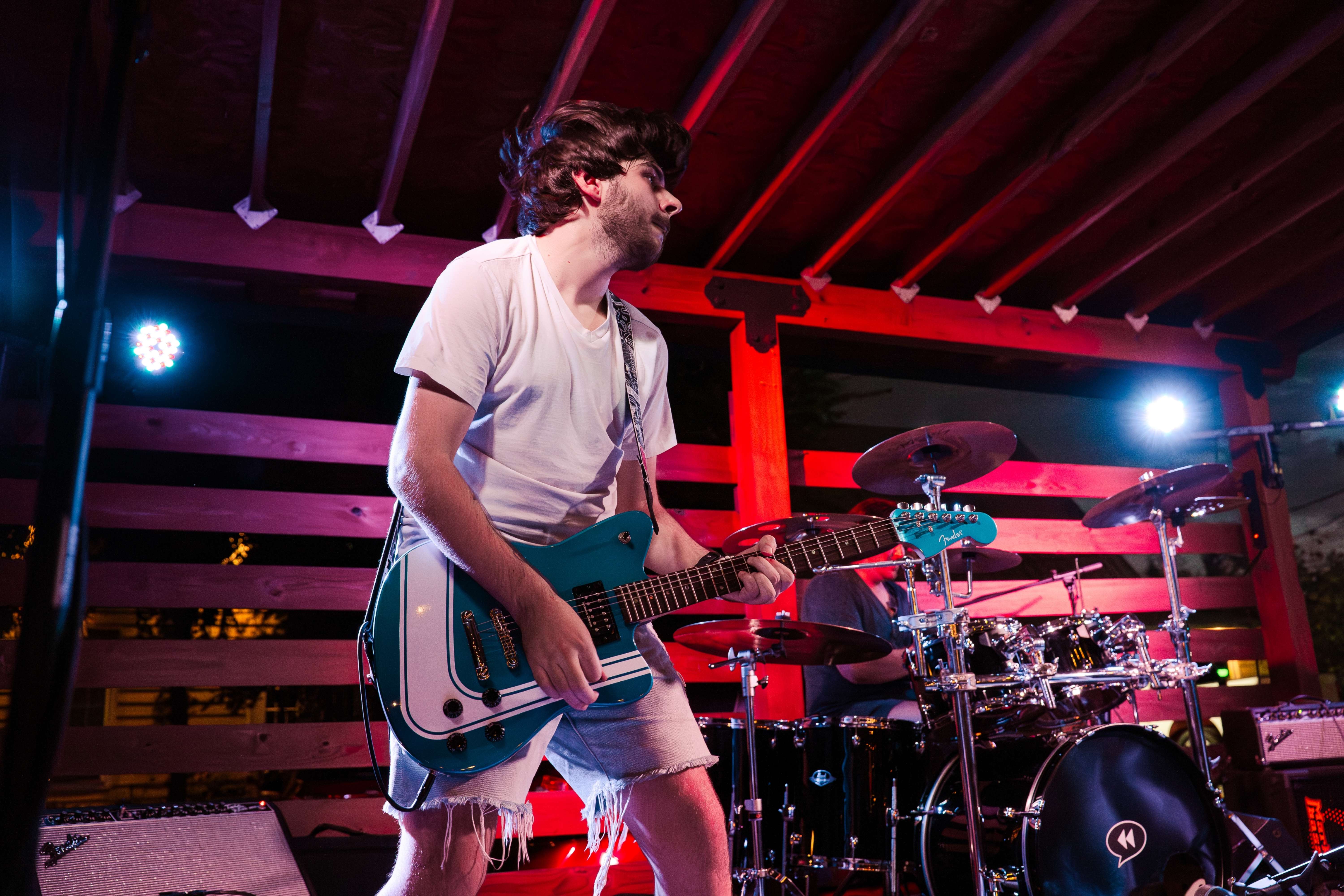 a man playing a guitar in front of a stage