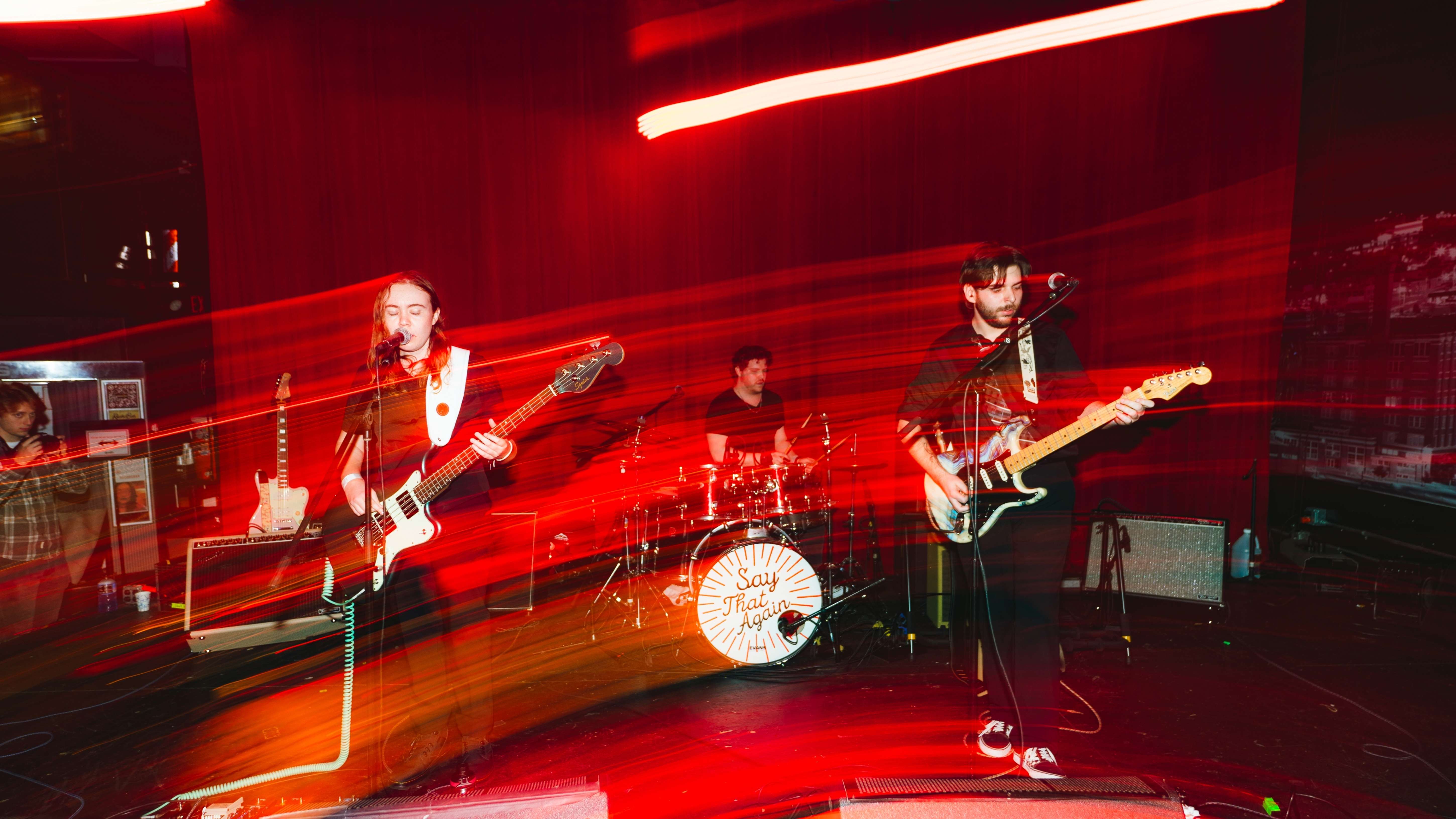 a group of people playing guitars in a dark room