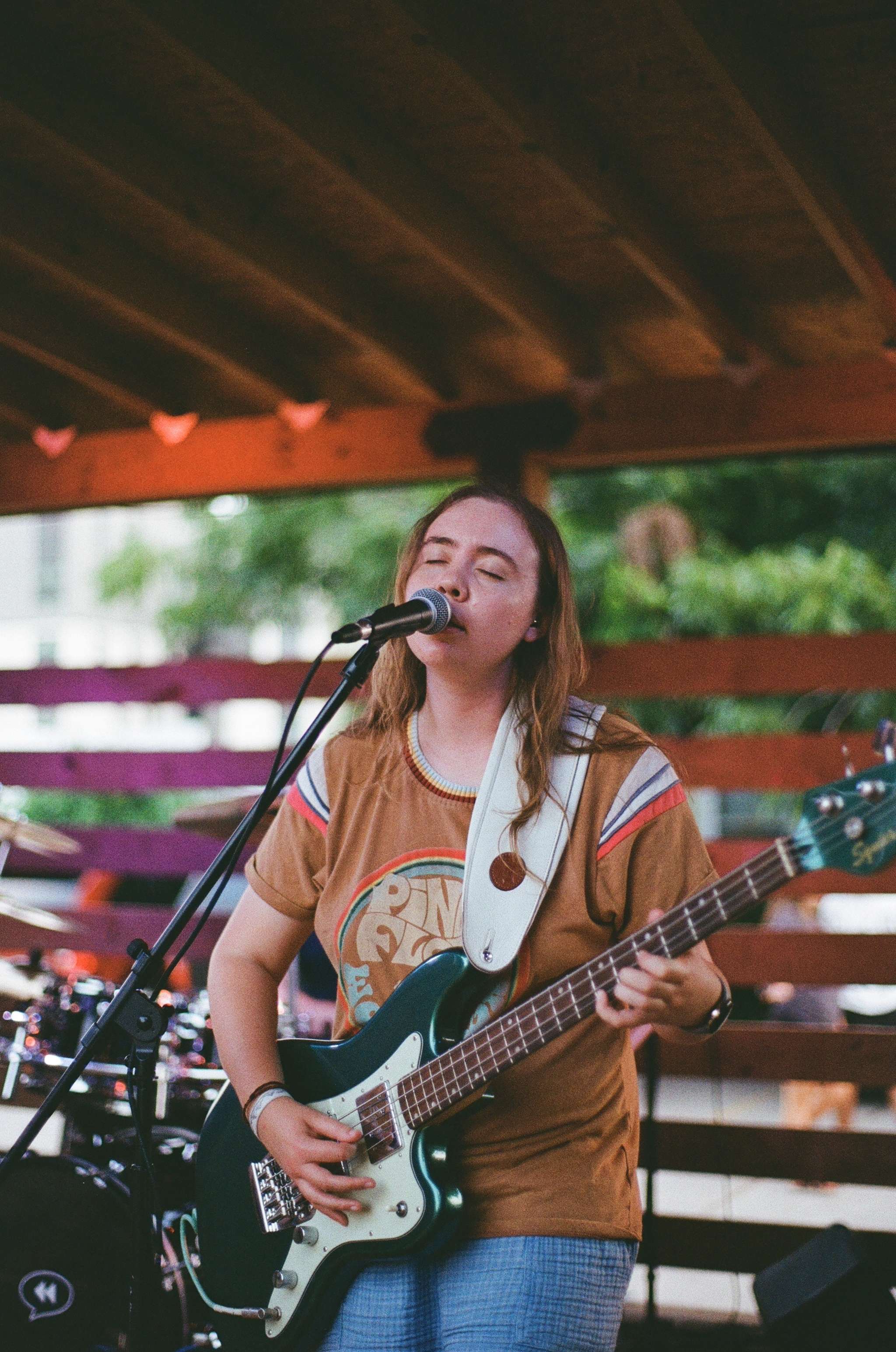 a woman playing a guitar on stage at an outdoor event