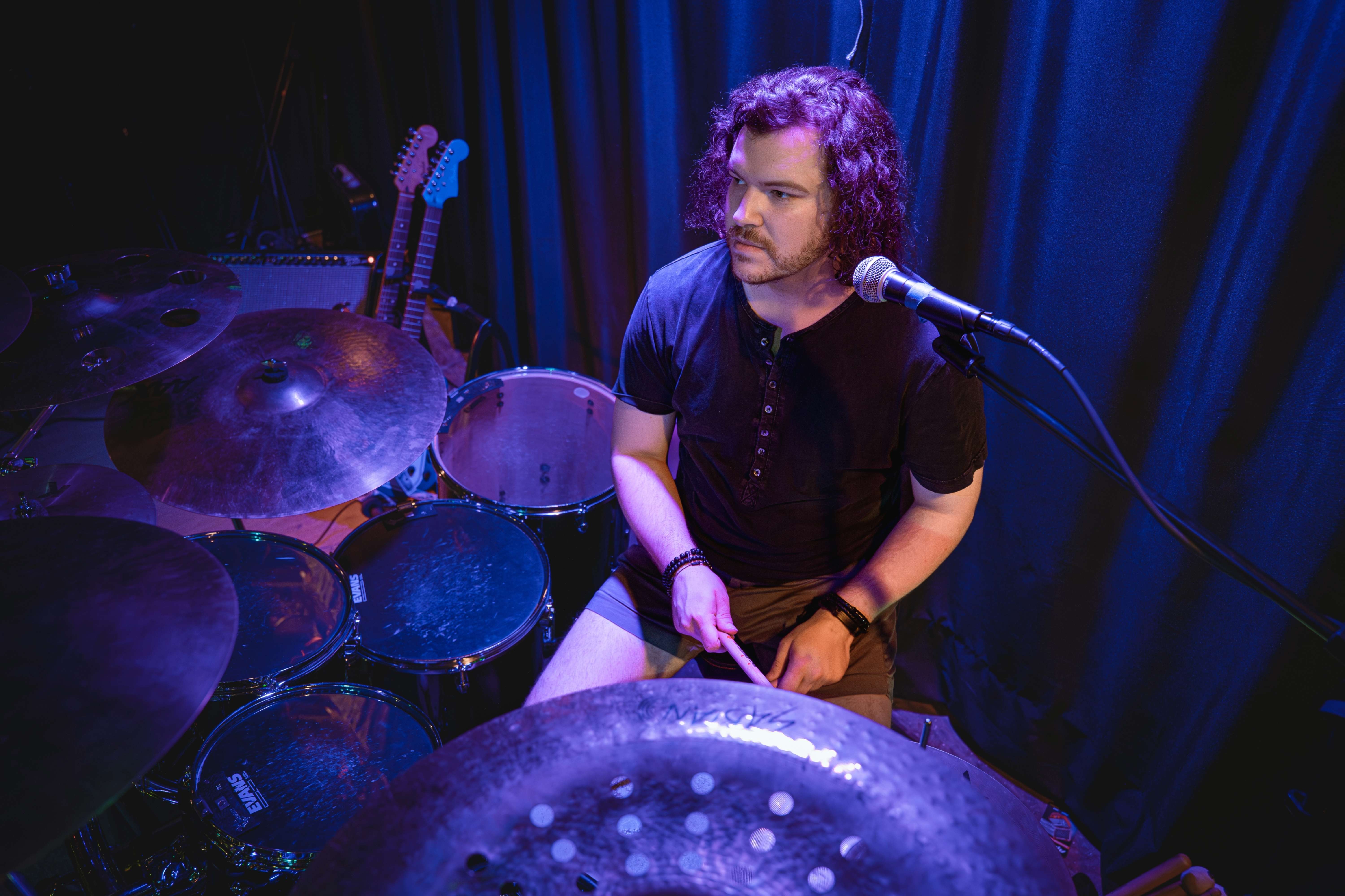 a man playing drums in front of a microphone