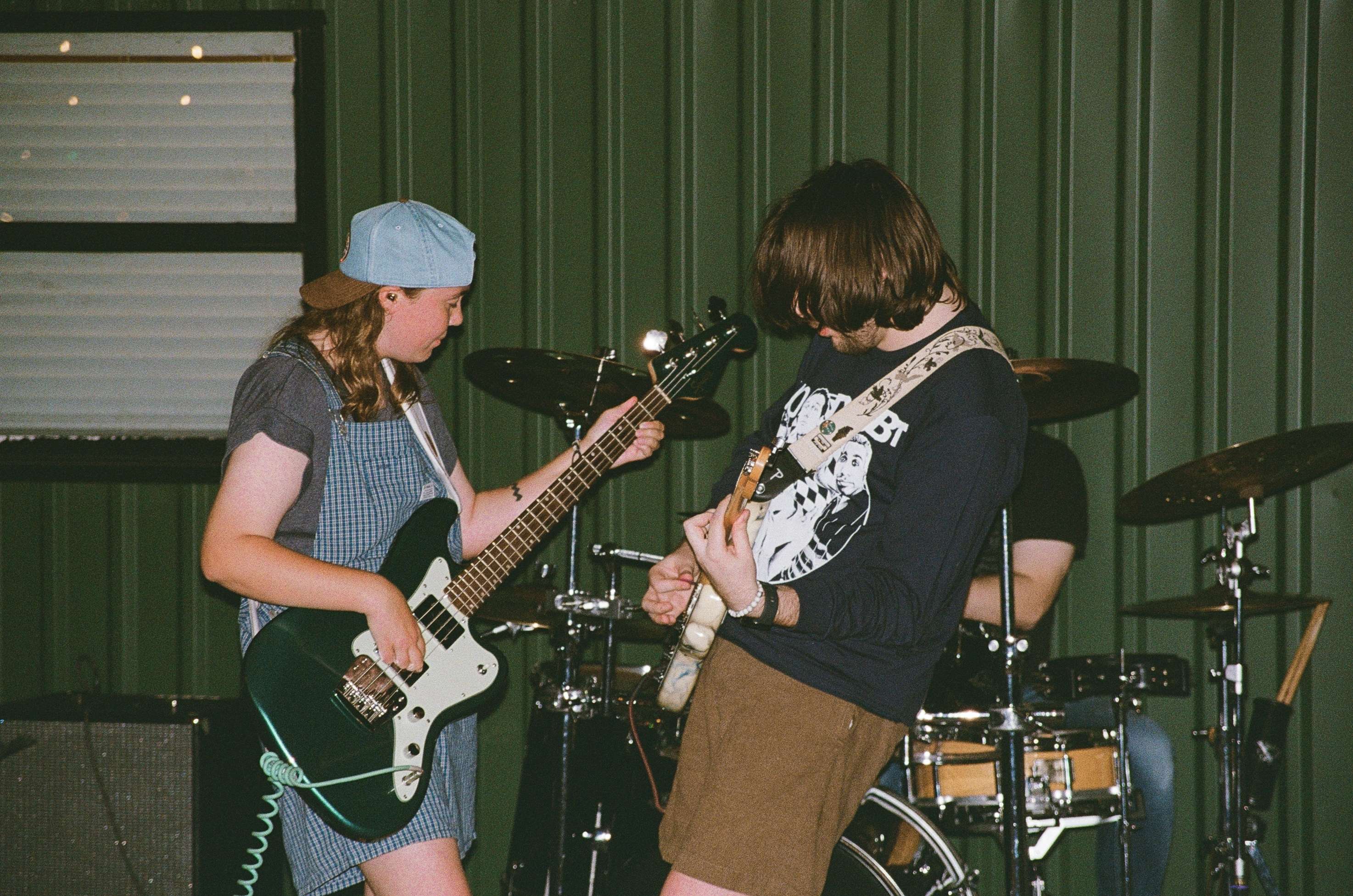 two people playing guitars in a band