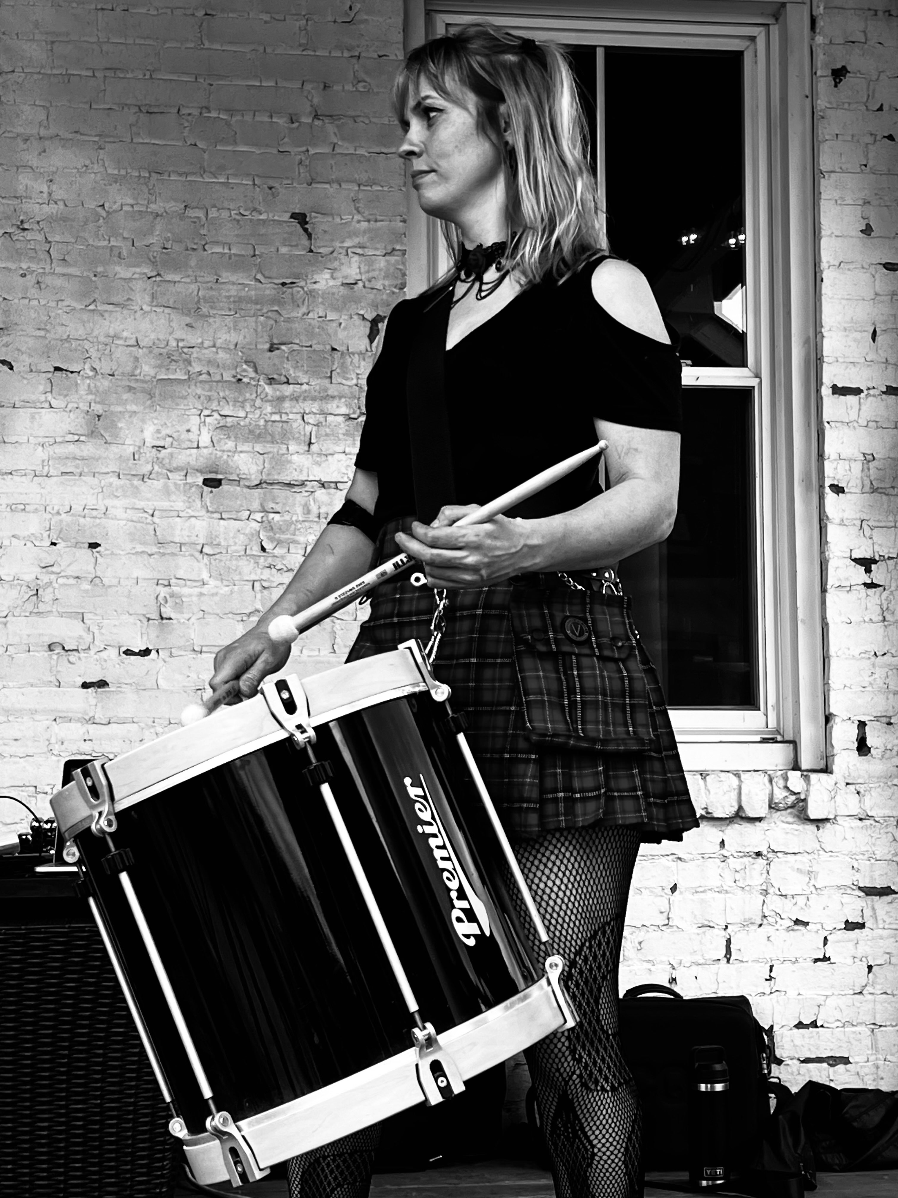 a black and white photo of a woman holding a drum