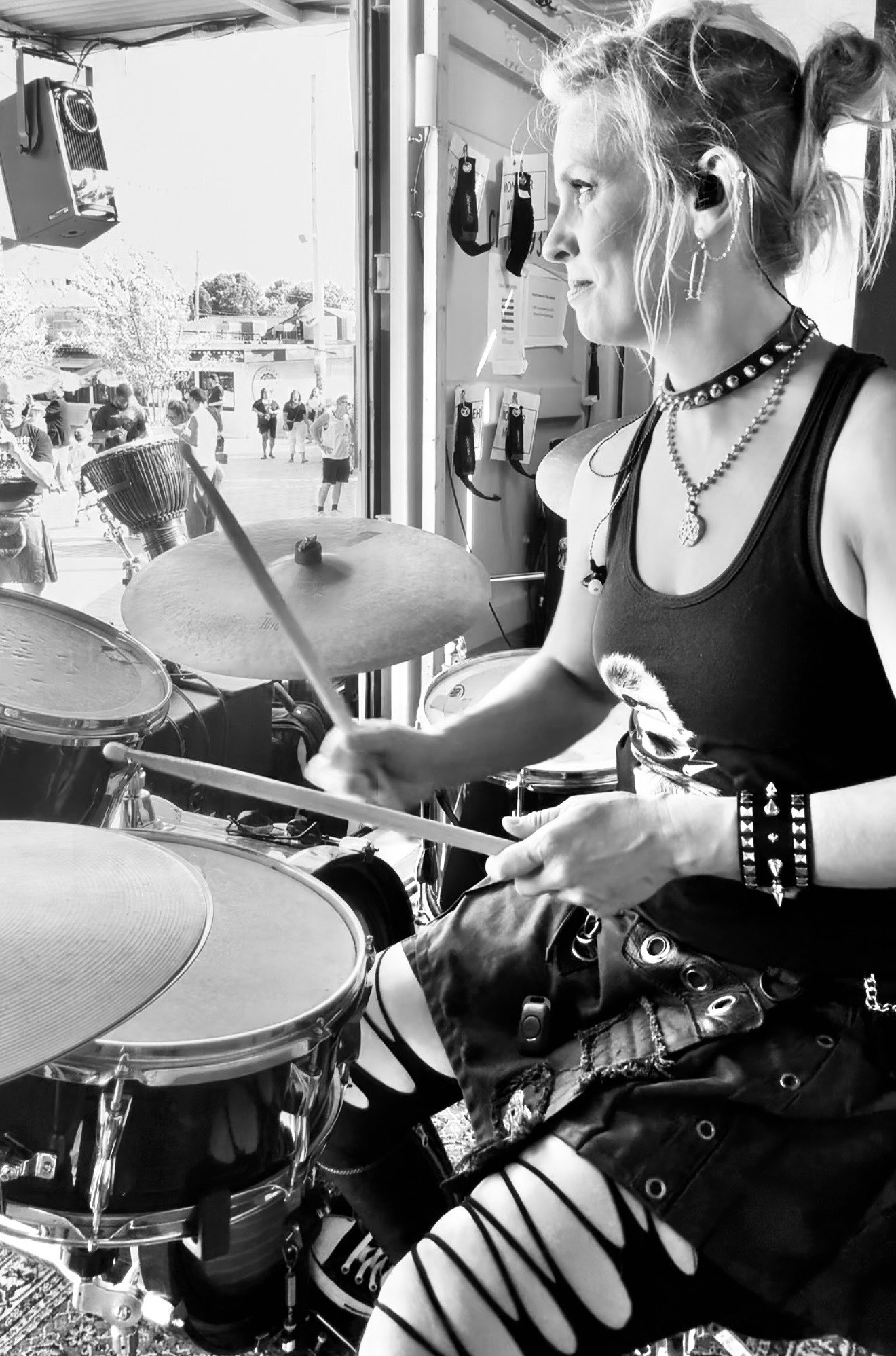 a black and white photo of a woman playing the drums