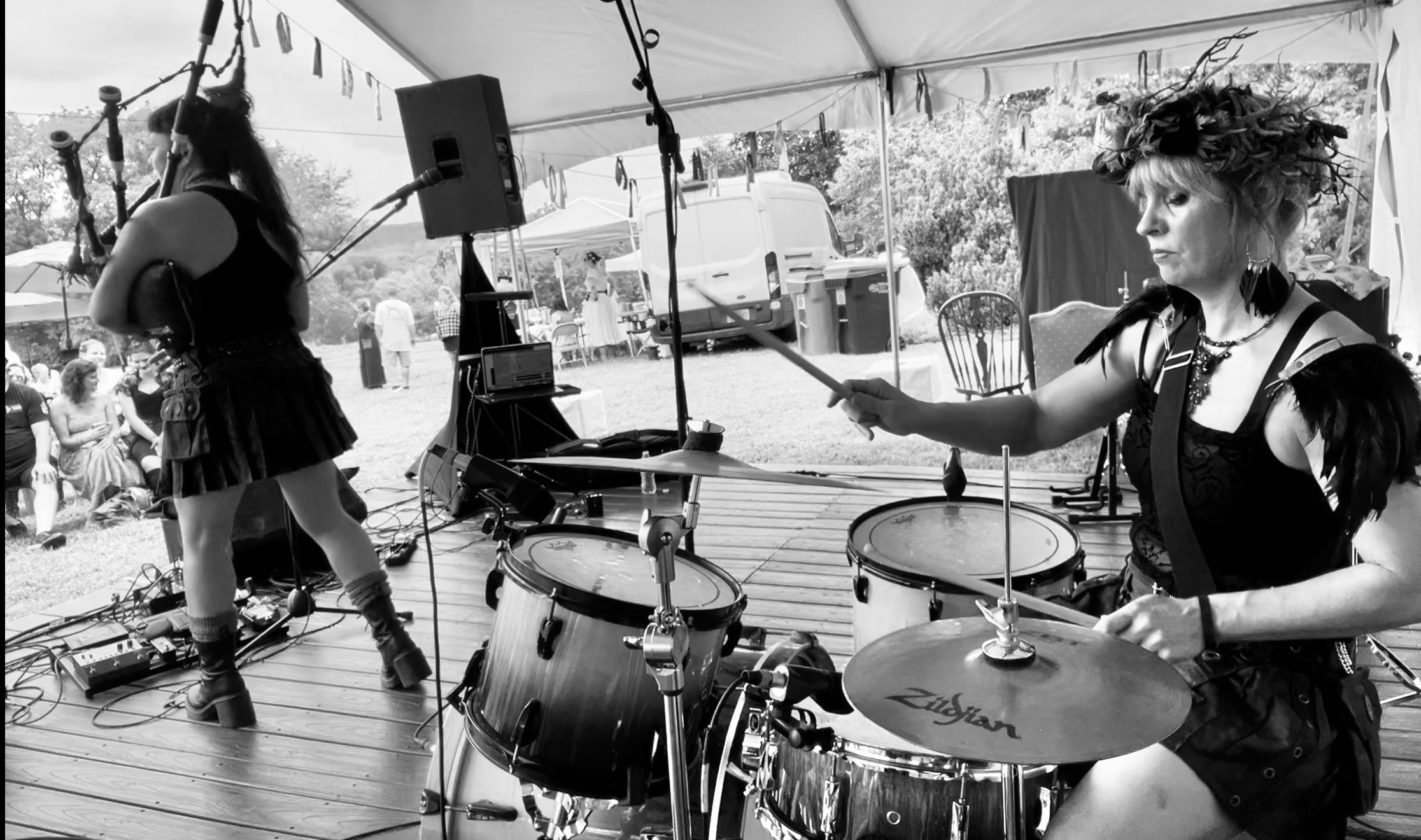 a black and white photo of two women playing drums