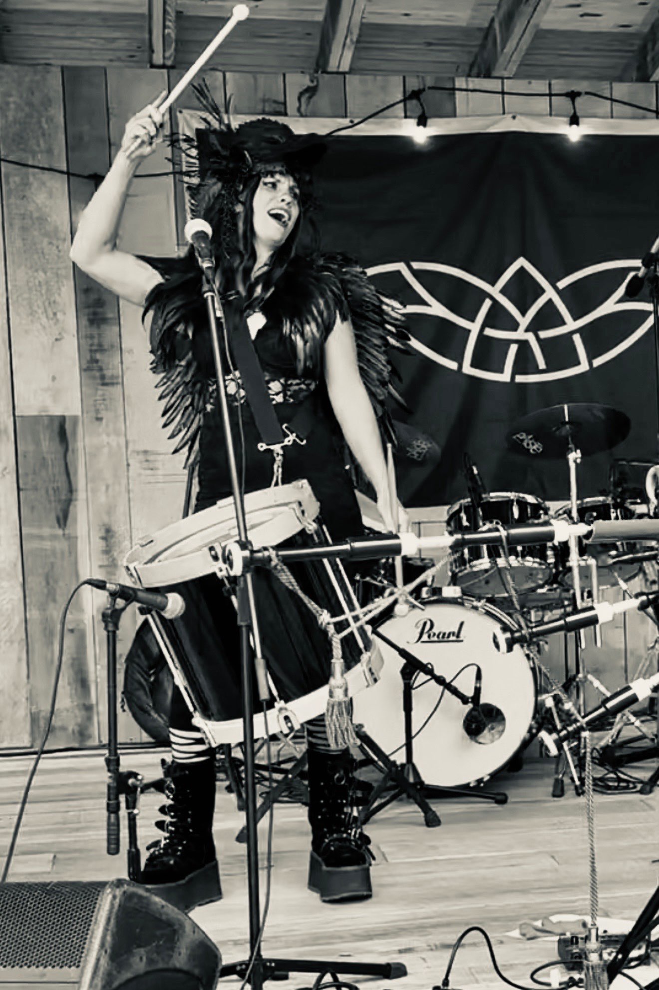 a black and white photo of a woman playing drums