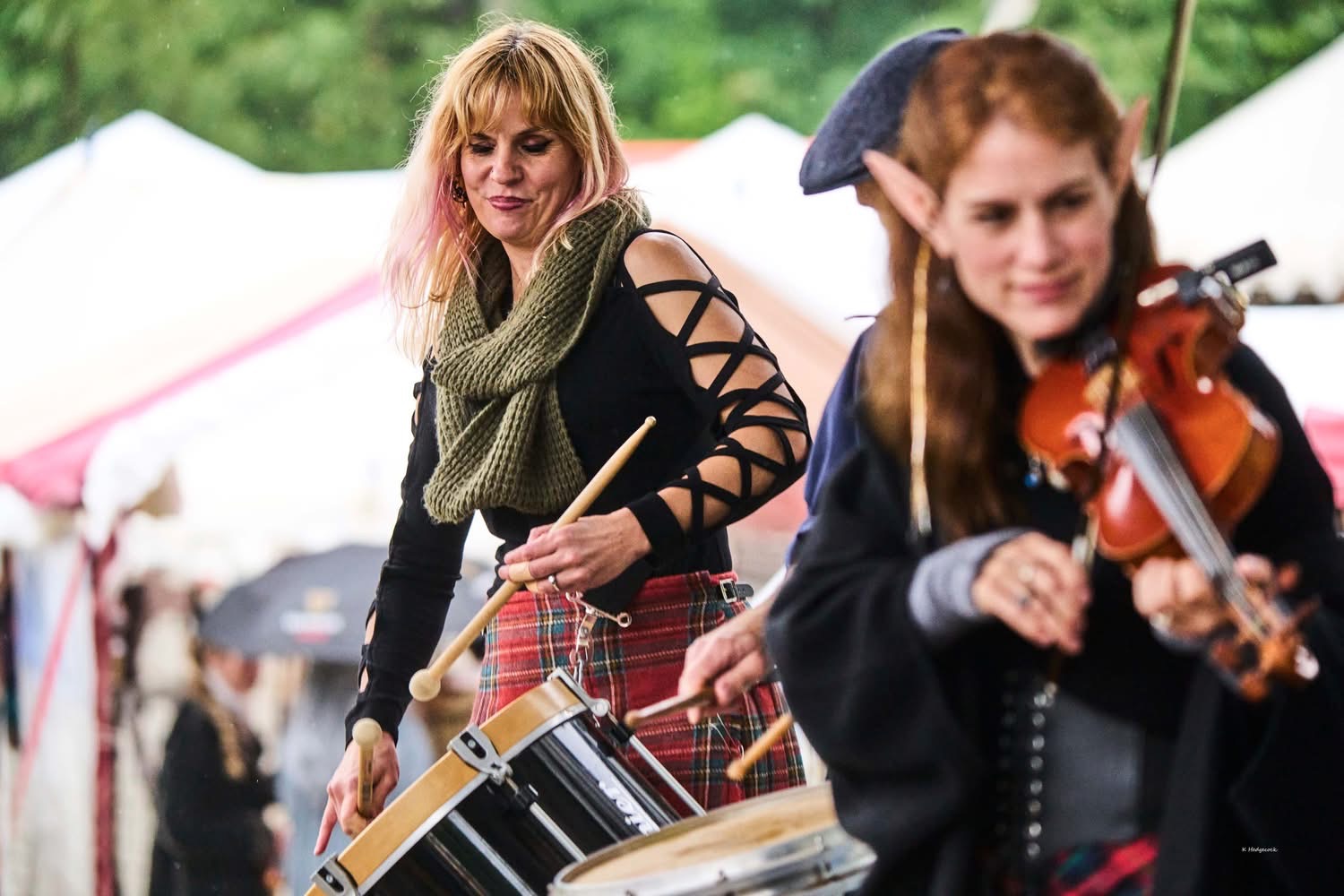 a group of women playing drums at an outdoor festival