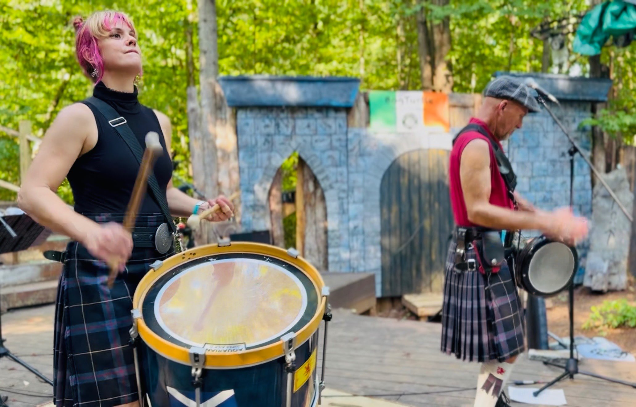 two people in kilts playing drums