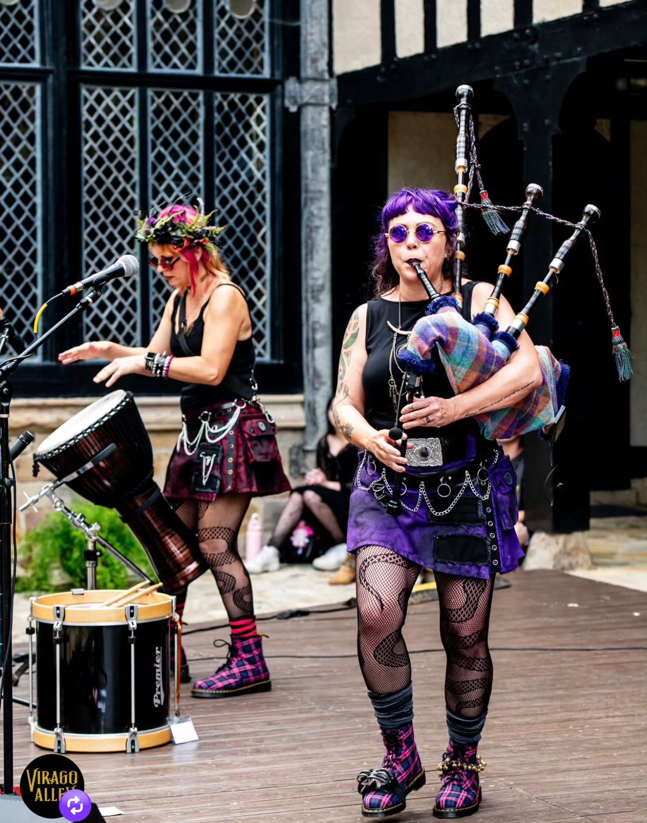 two women playing bagpipes on a stage