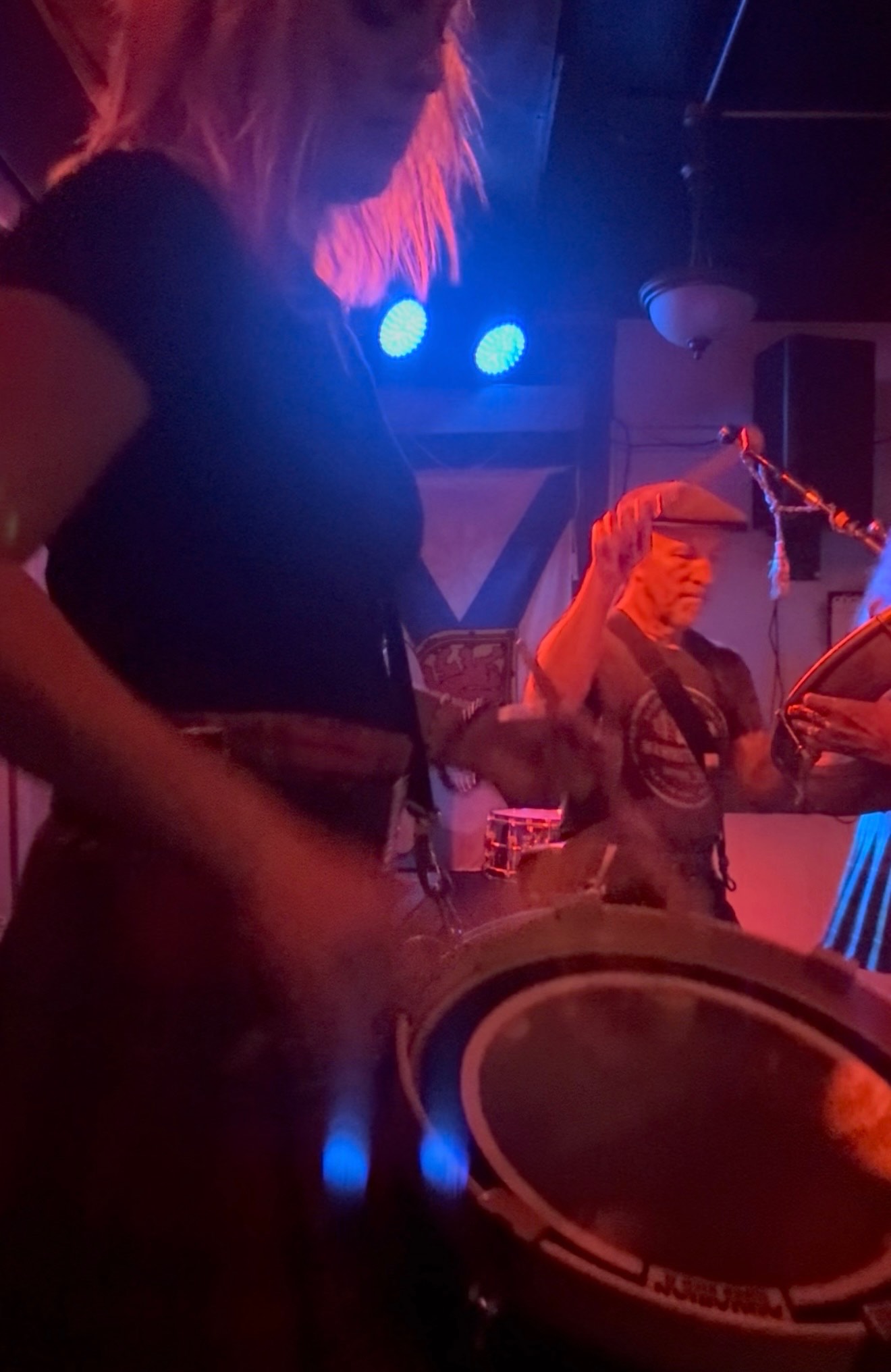 a group of people playing drums in a bar