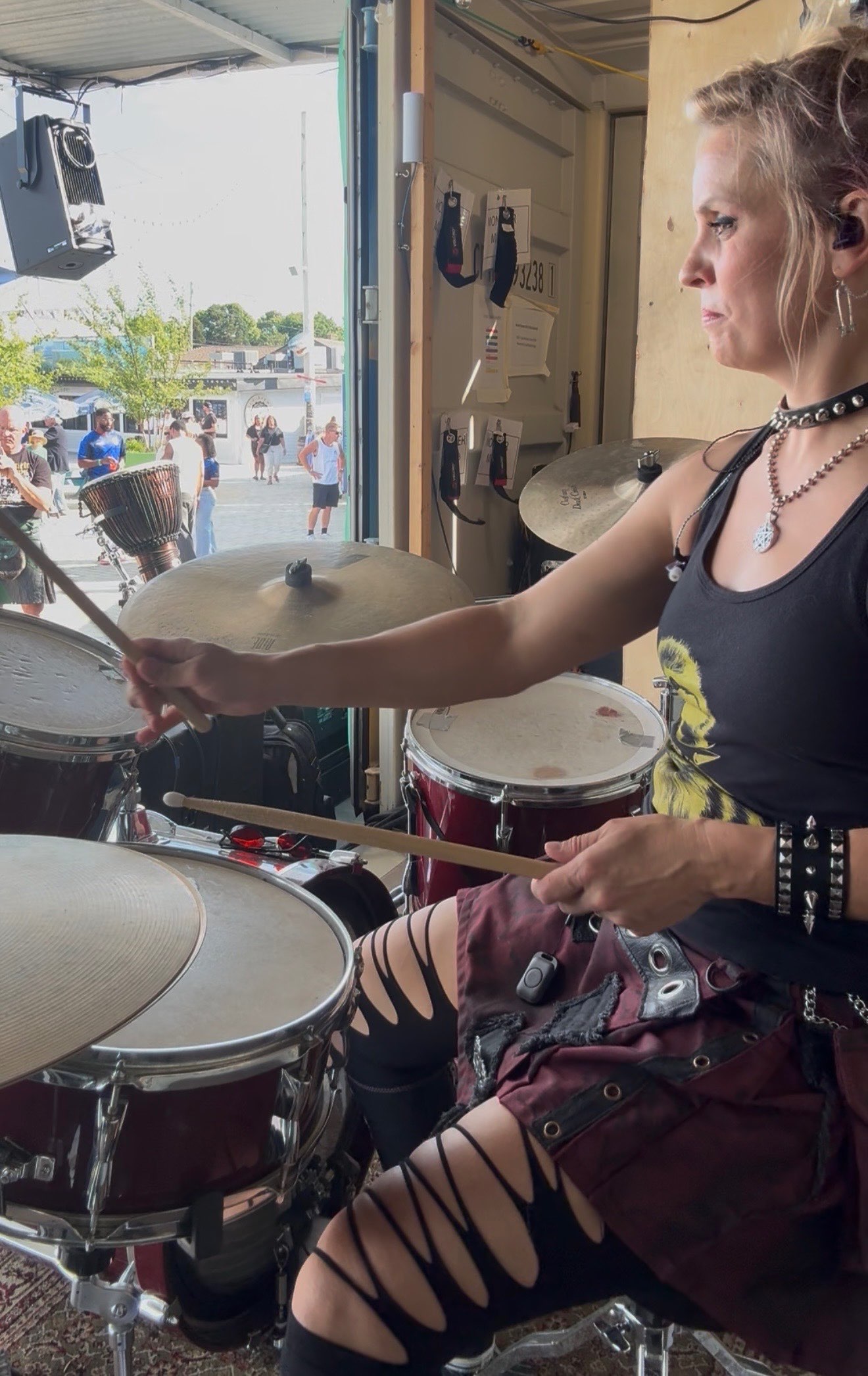 a woman playing drums in front of a crowd