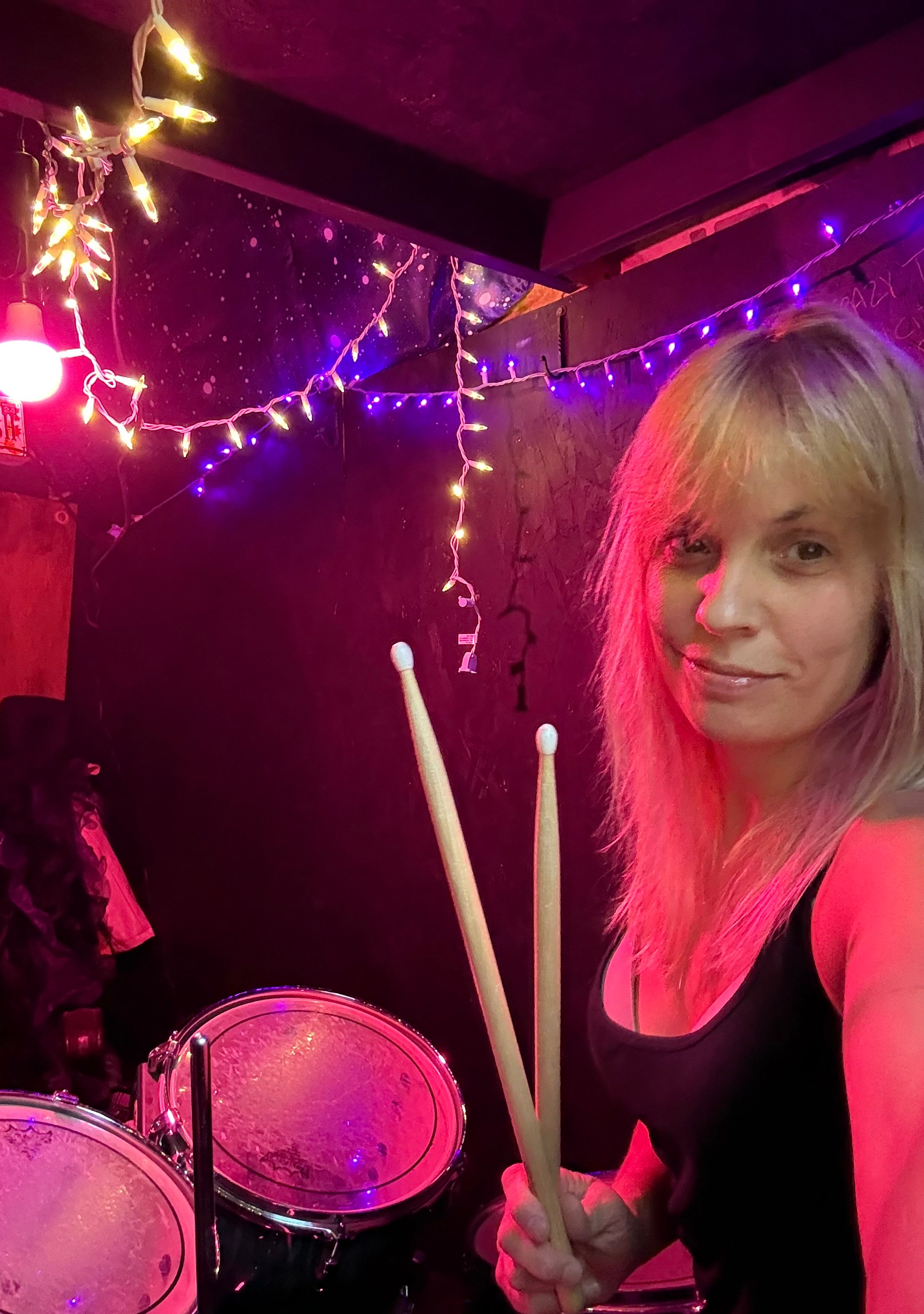 a woman holding a drum set in a dark room
