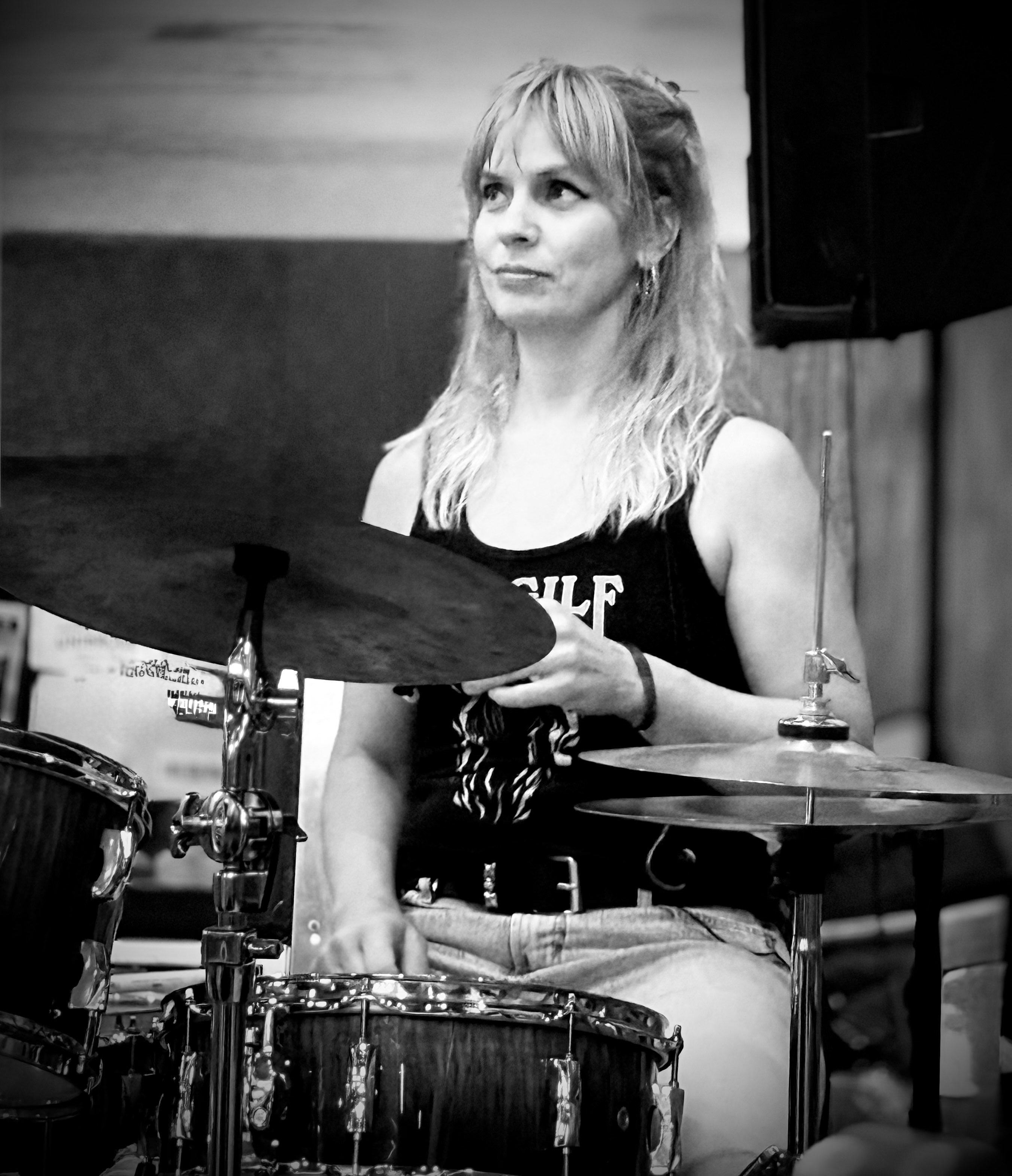 a black and white photo of a woman playing drums