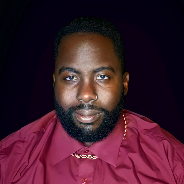 a man with a beard in a maroon shirt
