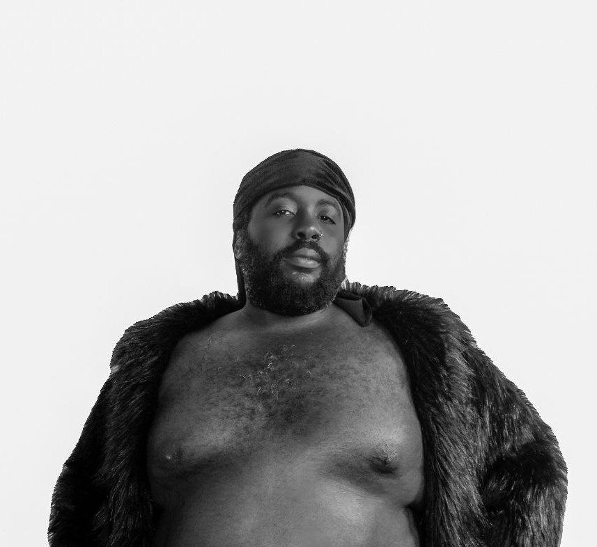 a black man in a fur coat posing for a photo