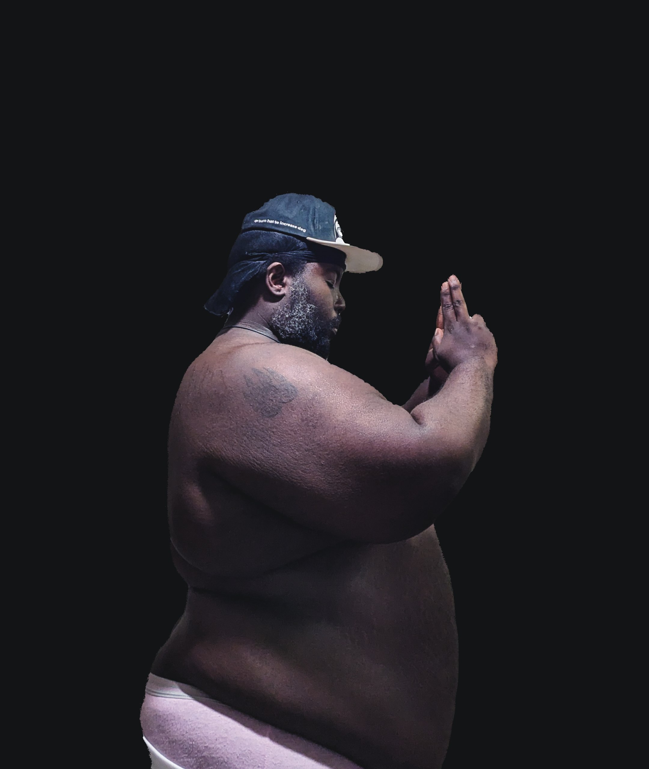 a man in a pink underwear is standing in front of a black background