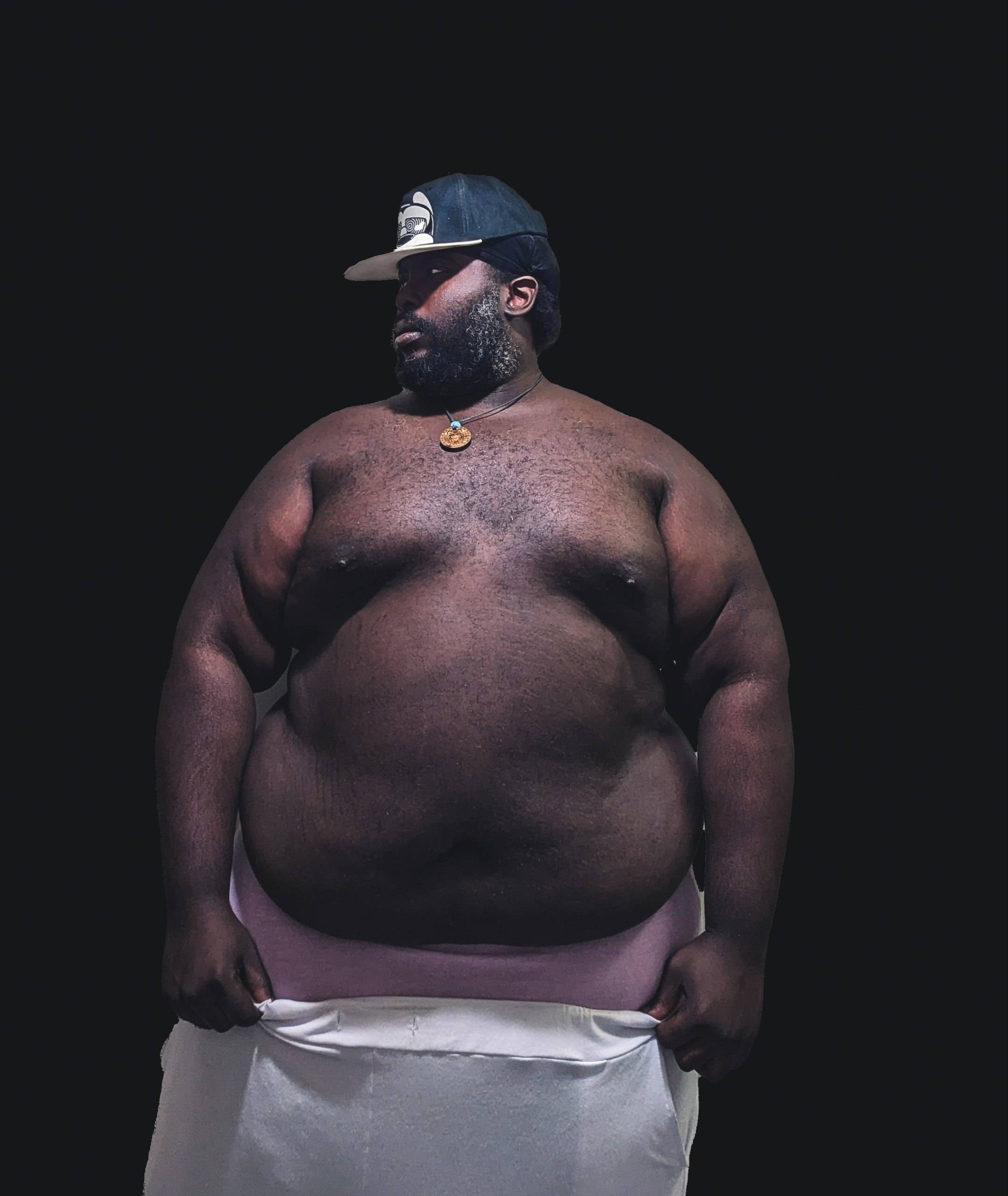 a man in a white shirt with a big belly
