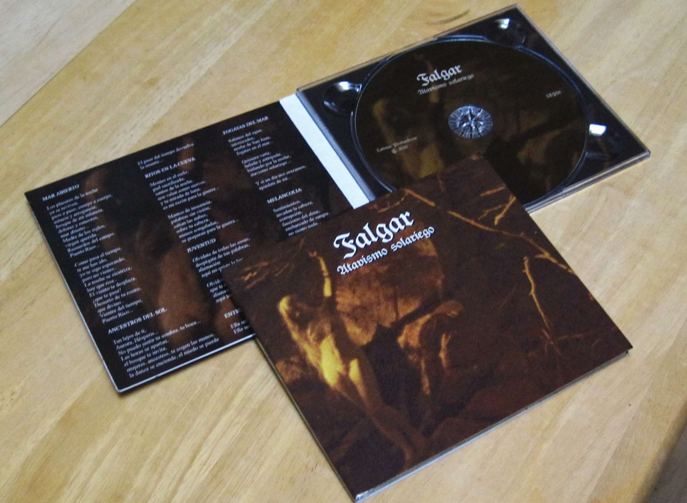a cd with a black cover on a wooden table