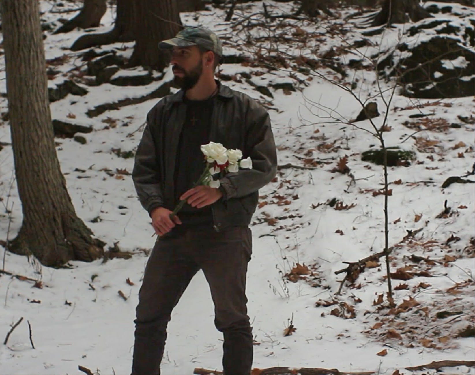 a man holding a bouquet of flowers in the snow
