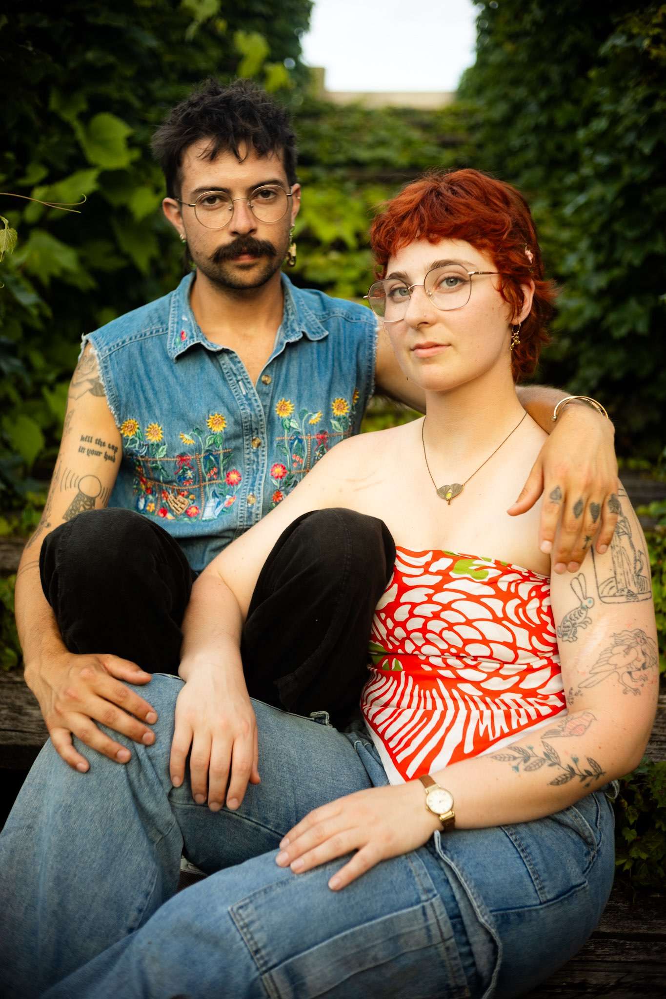 a man and woman with tattoos posing for a photo