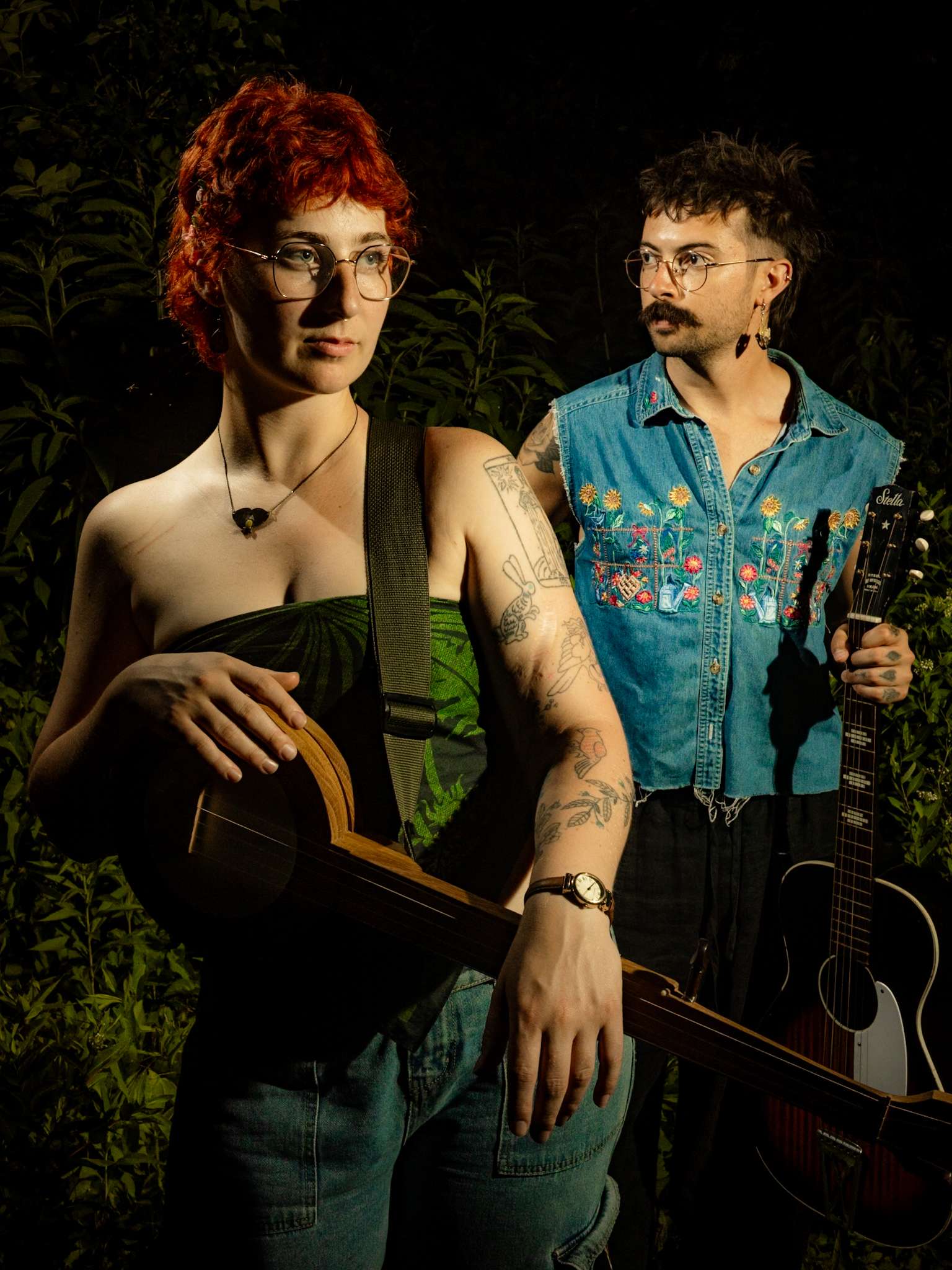 a man and a woman standing next to each other holding guitars