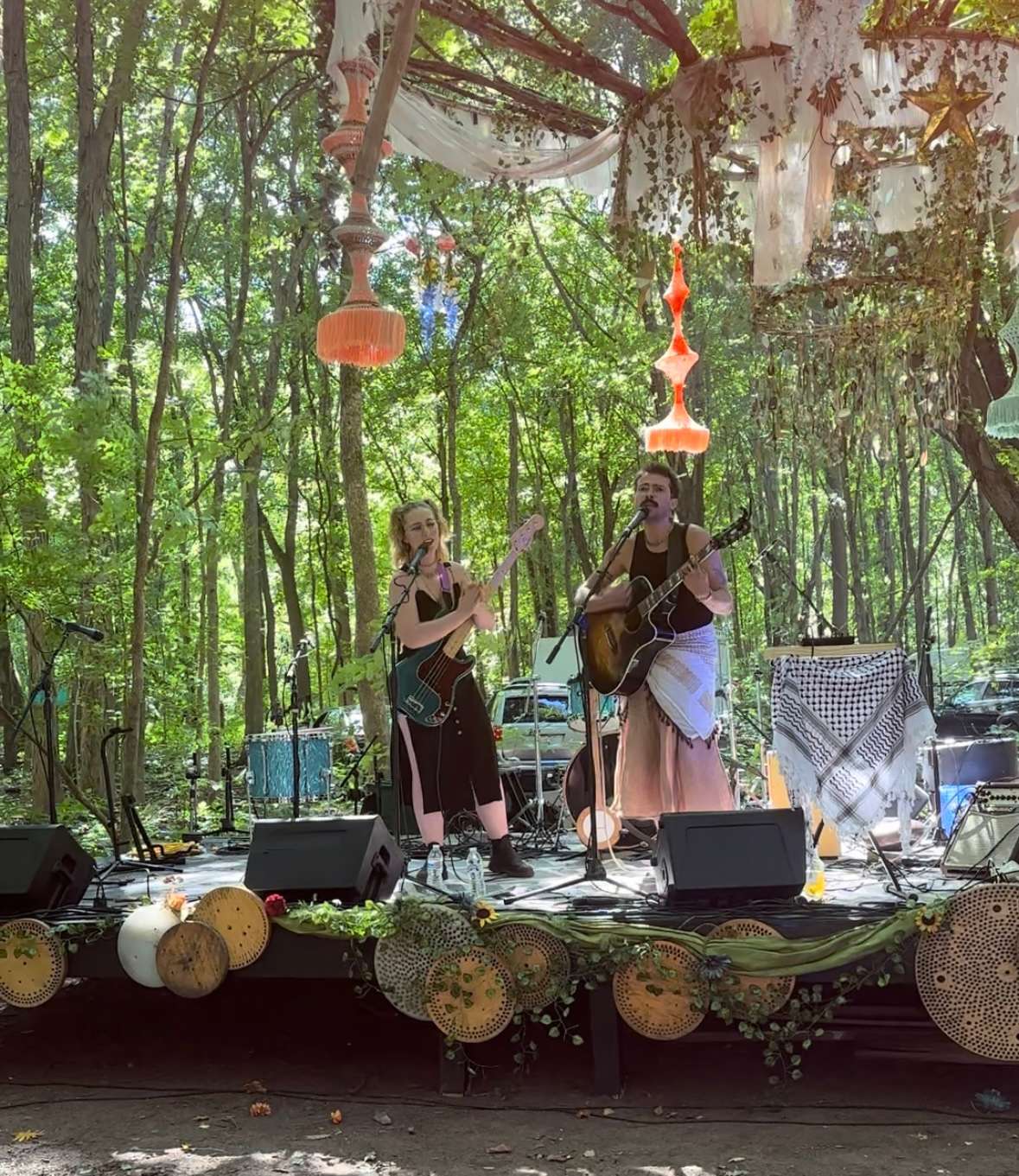a group of people on stage in a wooded area