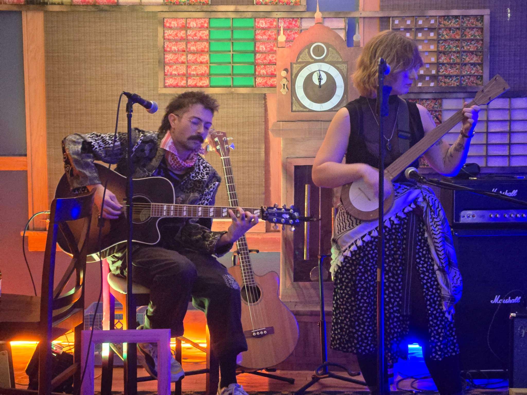 a group of people playing guitar and singing on stage