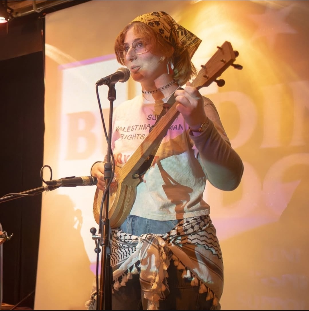 a woman playing an ukulele on stage