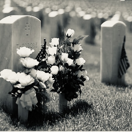 a black and white photo of a graveyard with flowers