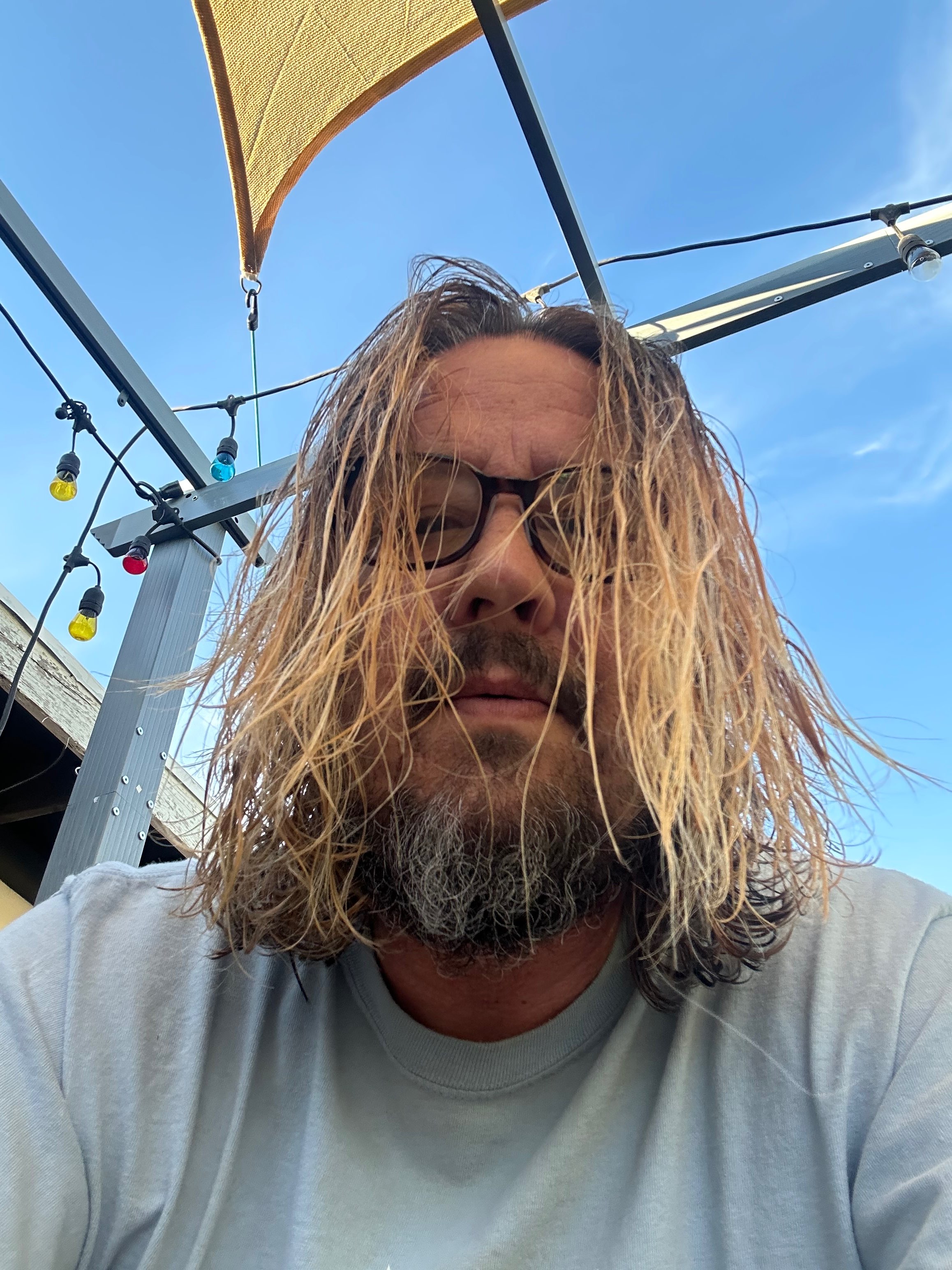 a man with long hair and glasses is taking a selfie