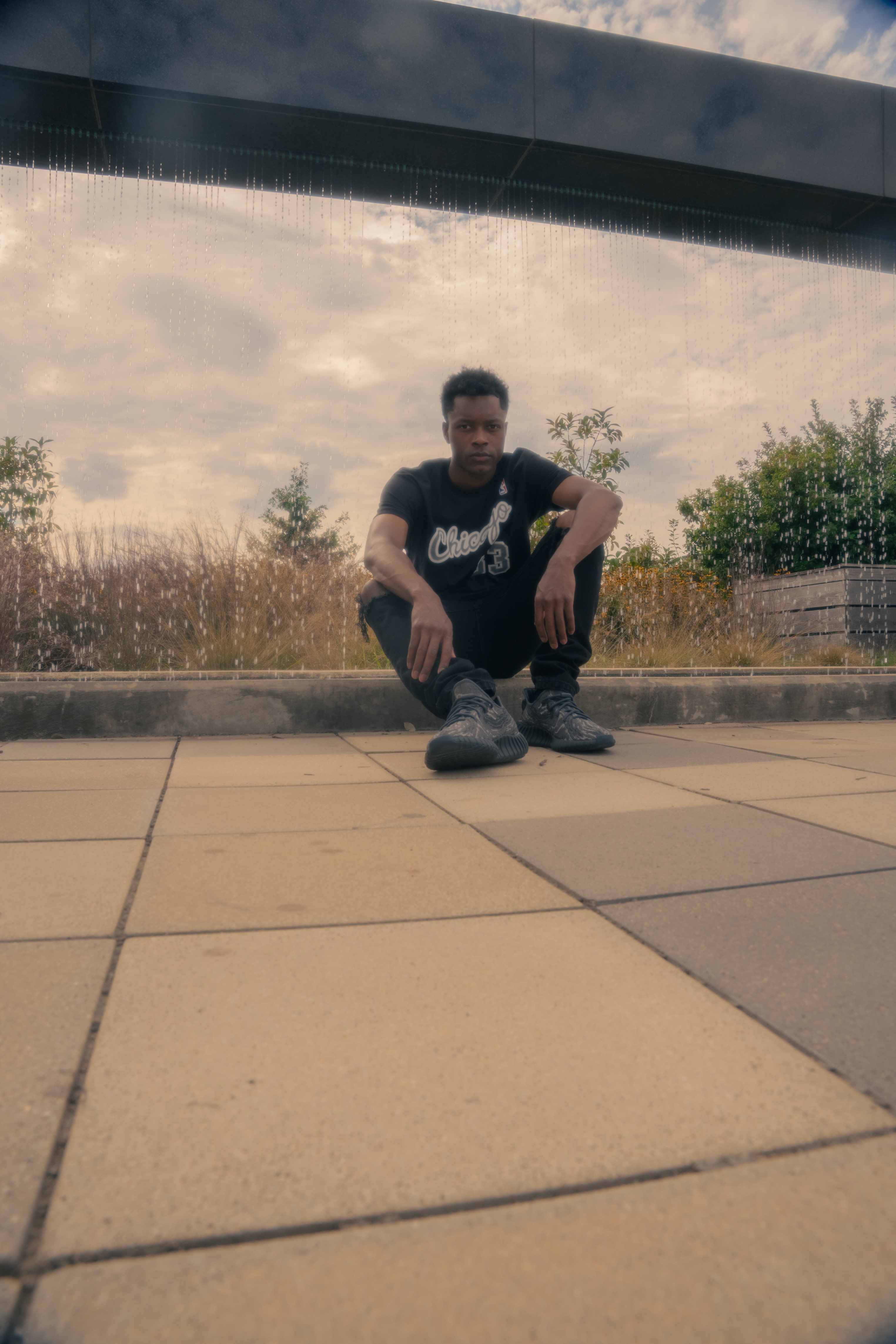 a man sitting on a skateboard in front of a fountain