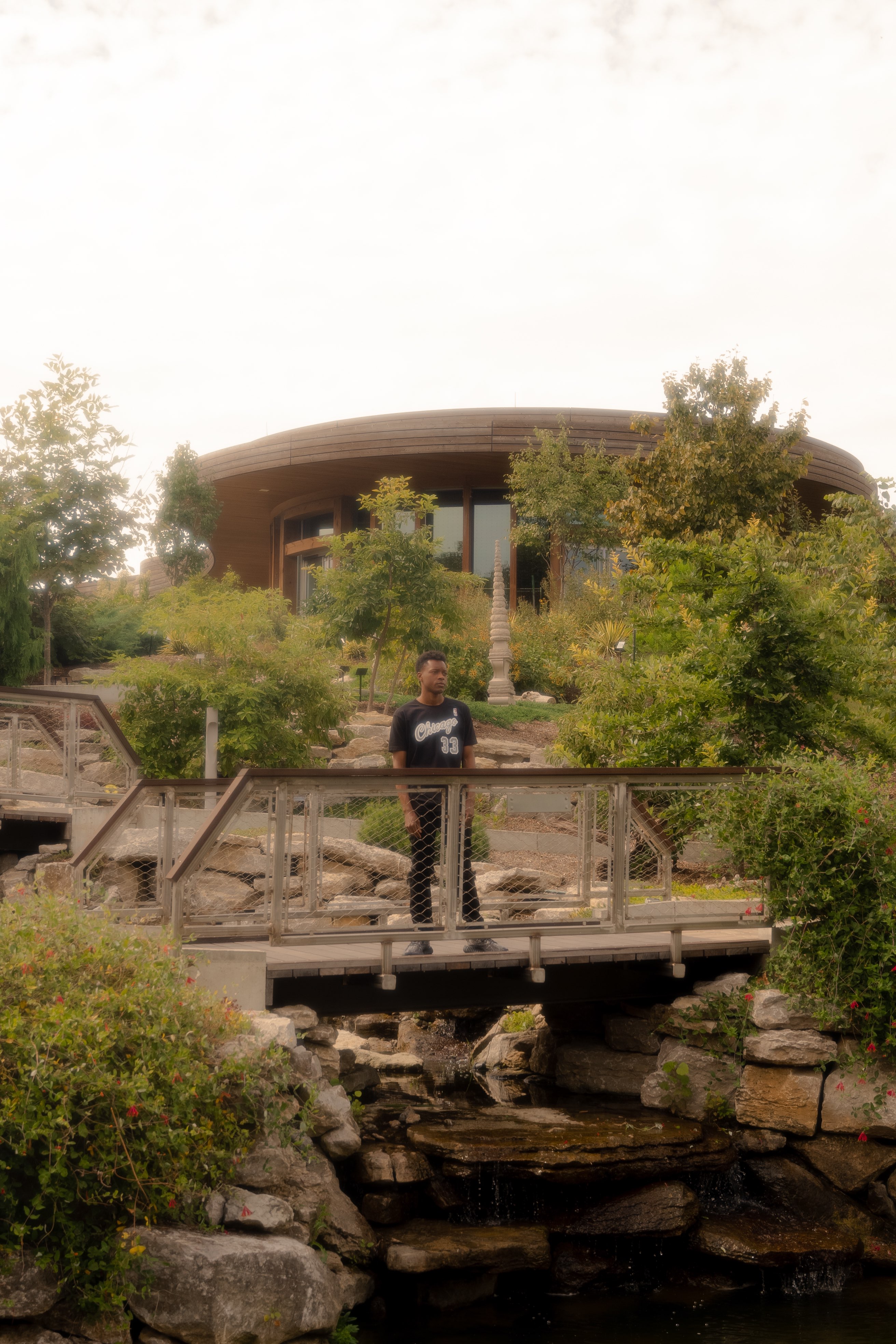 a man standing on a bridge over a pond