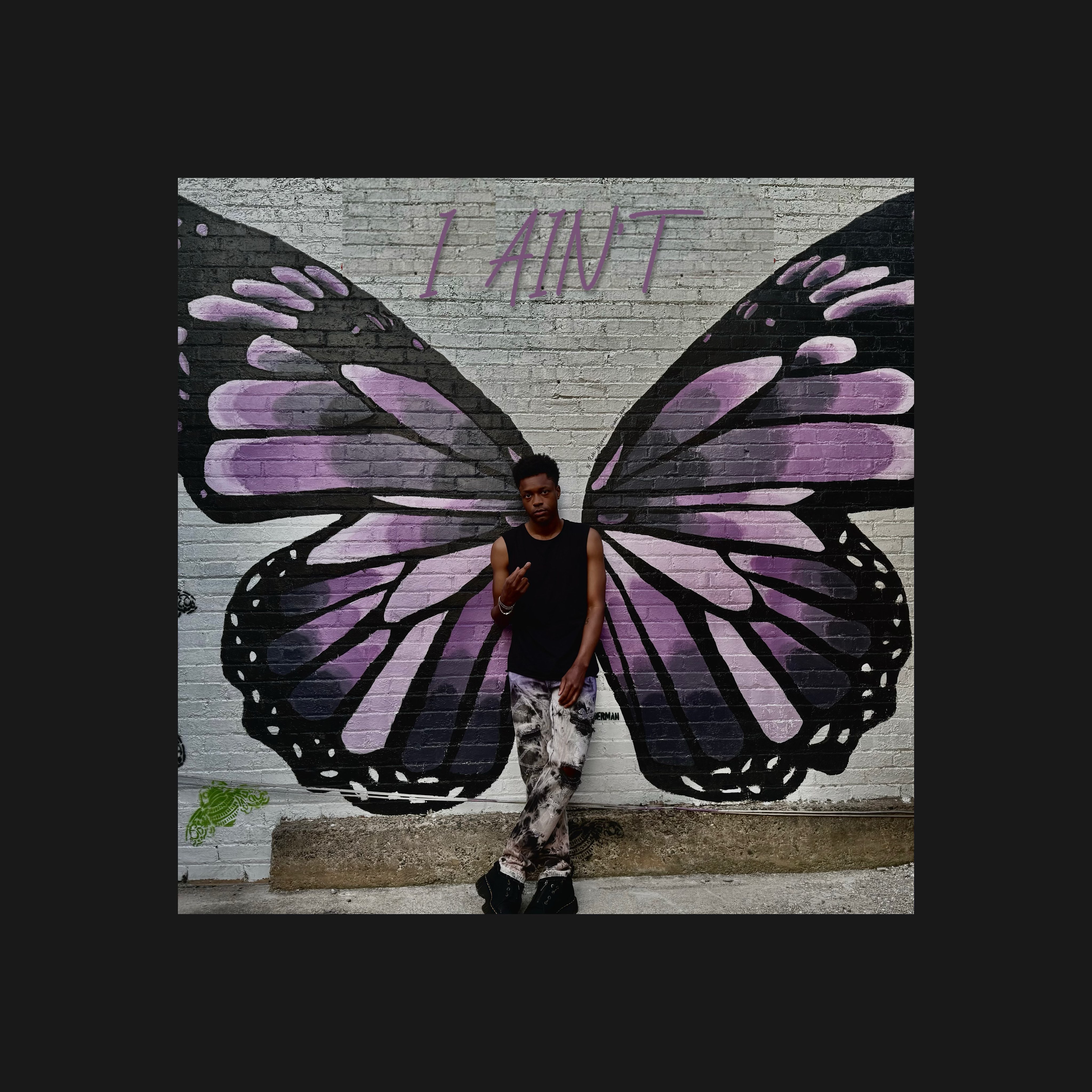 Nathan David - I AIN’T: a man standing in front of a butterfly painted on a wall