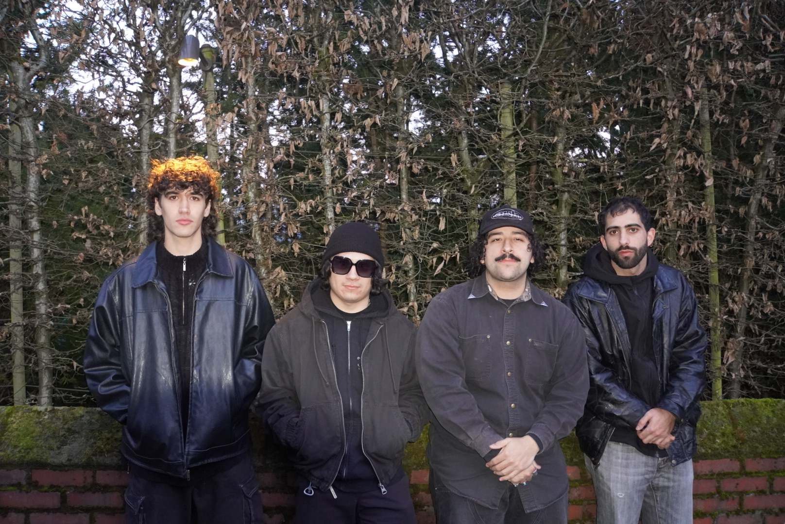 a group of men standing in front of a brick wall