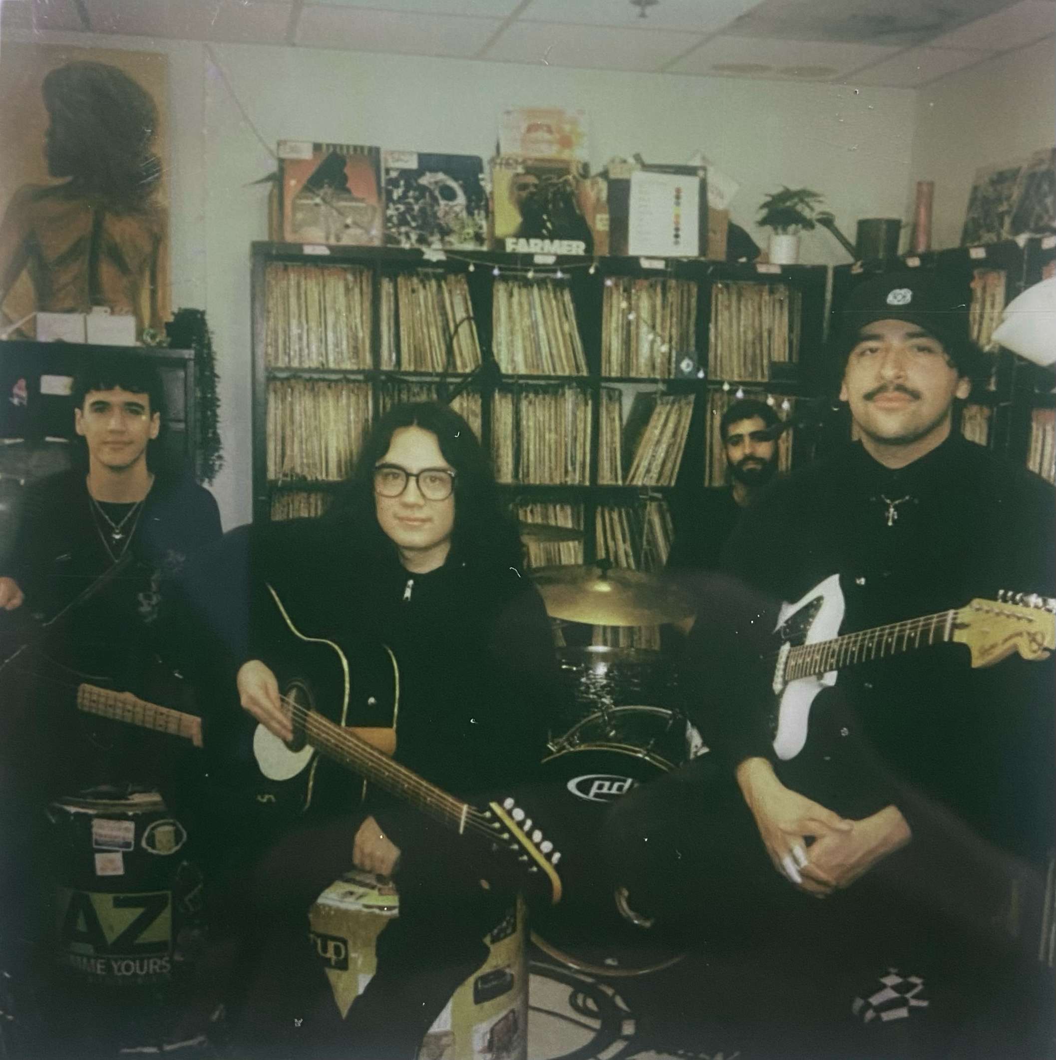 a group of men posing with guitars in a room