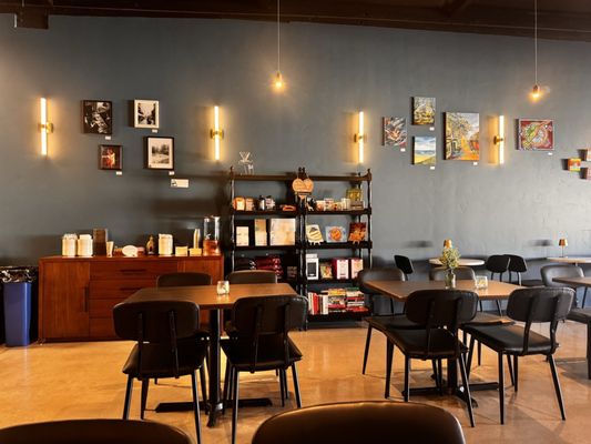 the interior of a coffee shop with tables and chairs