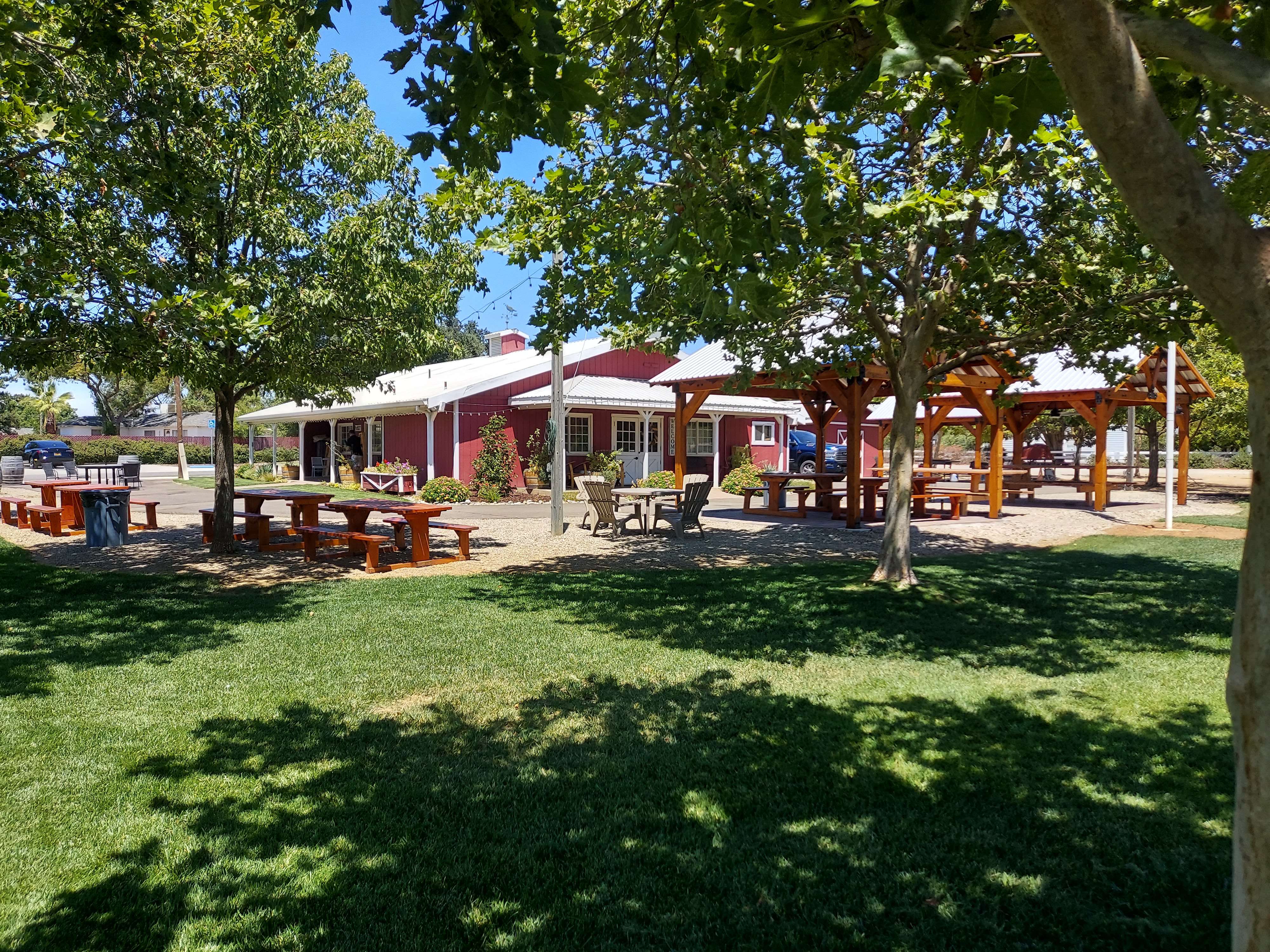 a park with picnic tables and a red barn
