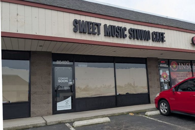 a car is parked in front of a store that says sweet music studio care